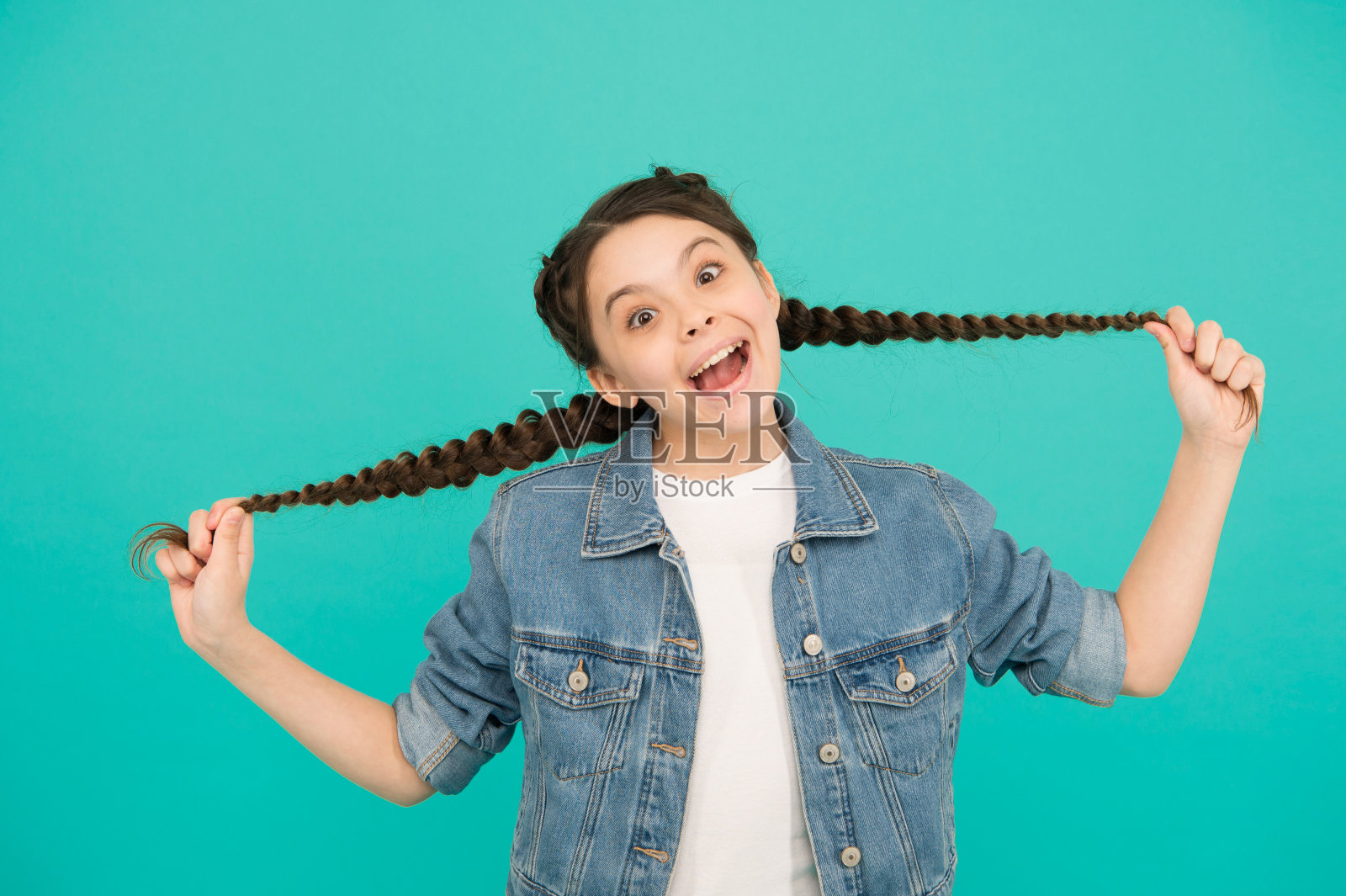 一直想当理发师。快乐的女孩挽着长发蓝色的背景。儿童理发师和发型师。儿童美发沙龙。美容院。发型设计师和发型师。我的理发师照片摄影图片