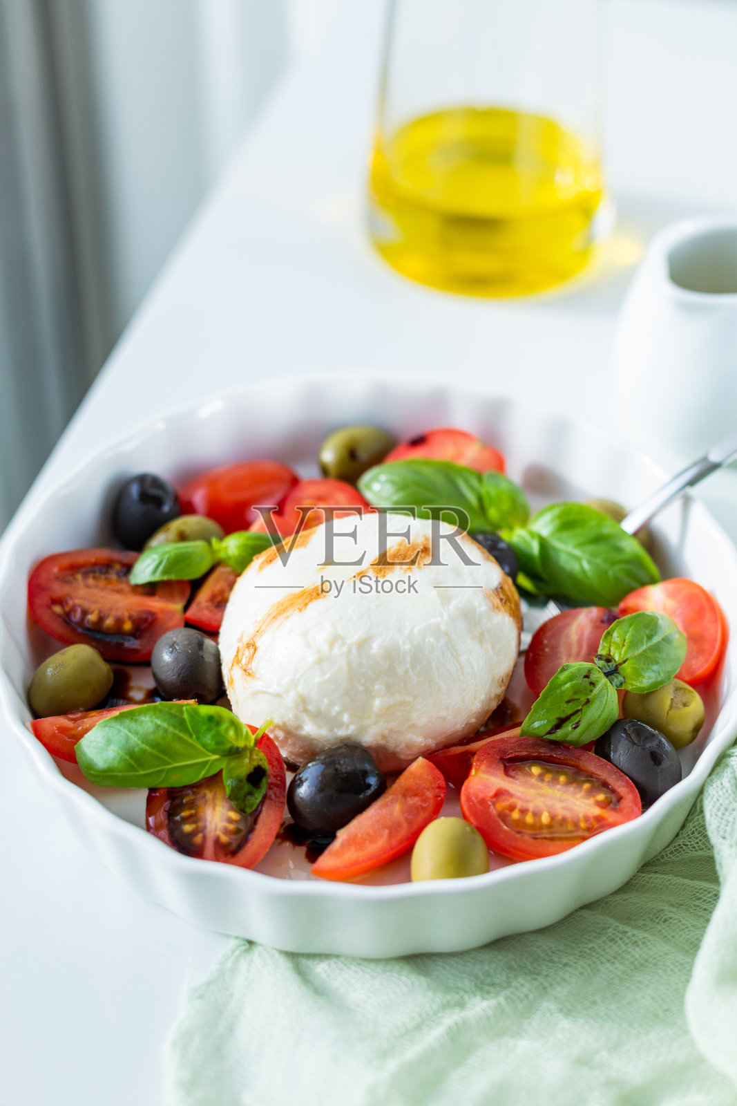 马苏里拉奶酪沙拉、红酒杯和橄榄照片摄影图片