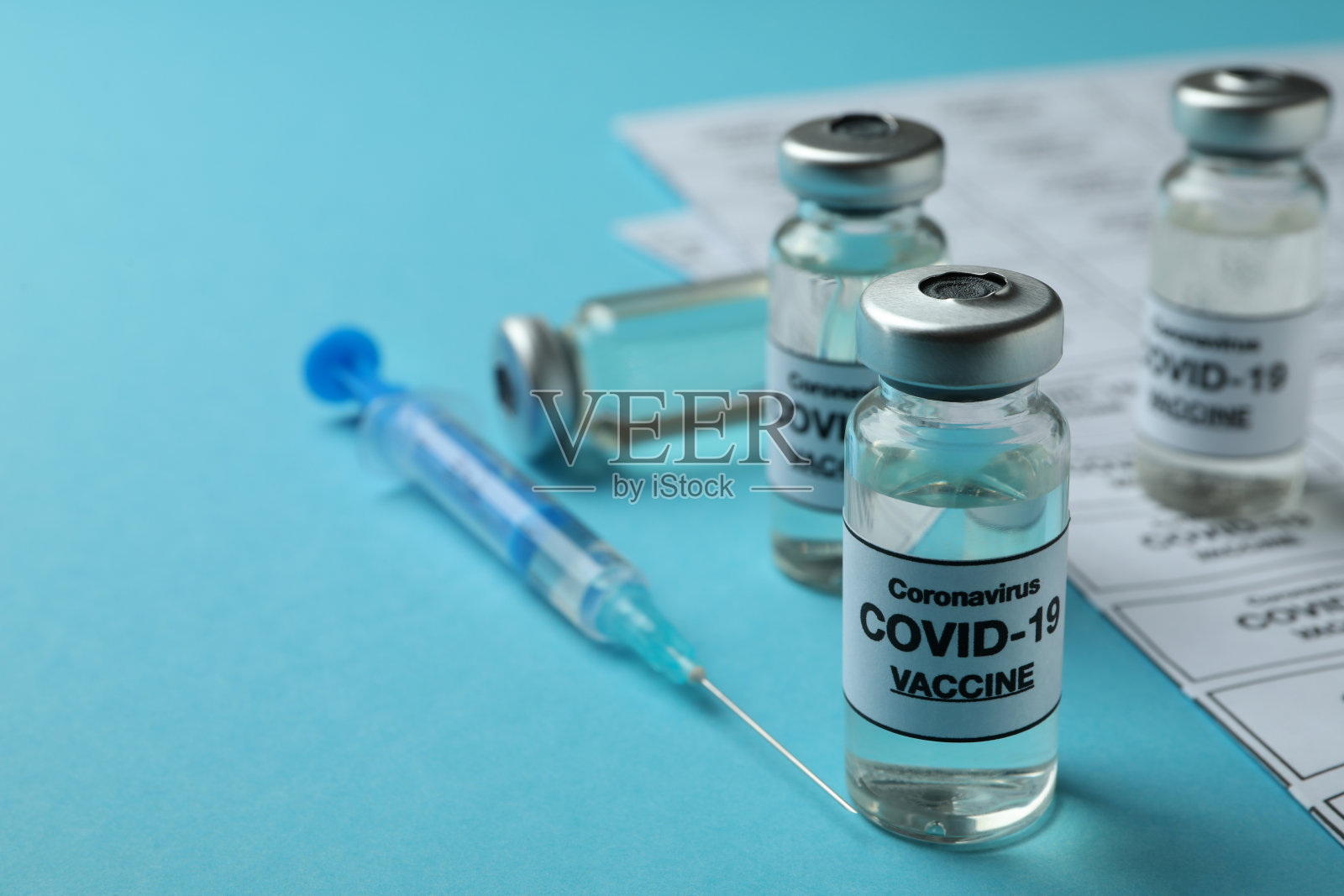 用小瓶和注射器接种Covid - 19的概念，蓝色背景照片摄影图片