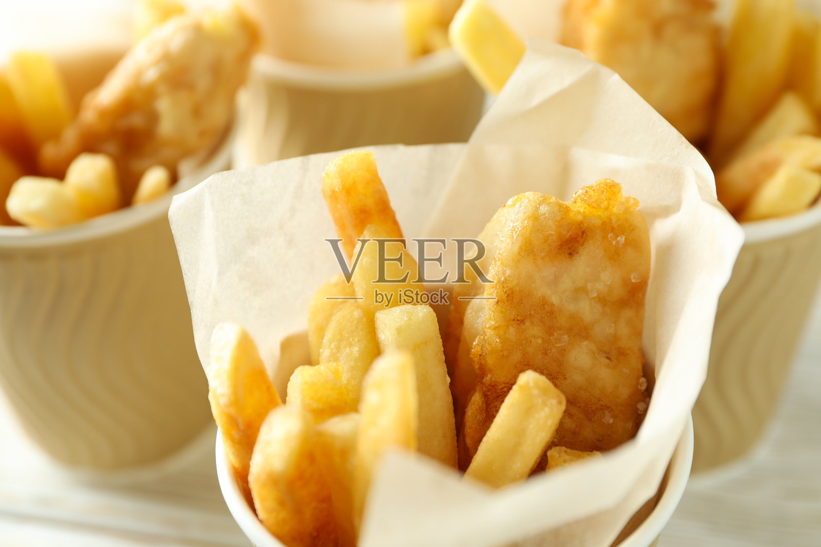 装着炸鱼和薯条的纸杯，特写照片摄影图片