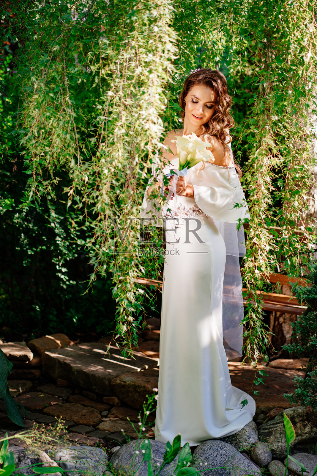 新娘有卷发，穿着露肩礼服，一束柳树花束照片摄影图片