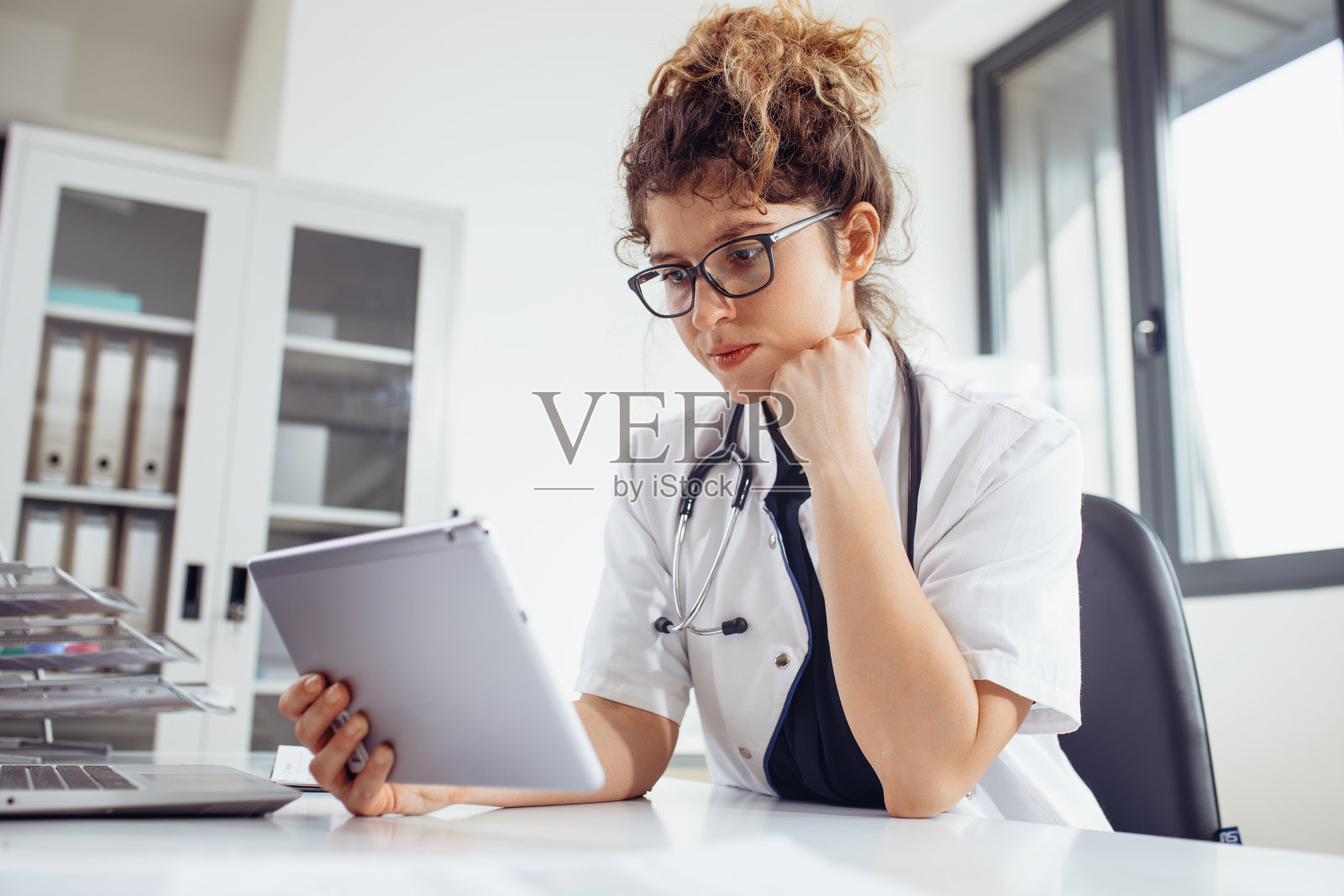 女医生使用平板电脑与同事进行视频通话。医生使用平板电脑与患者进行视频通话。照片摄影图片