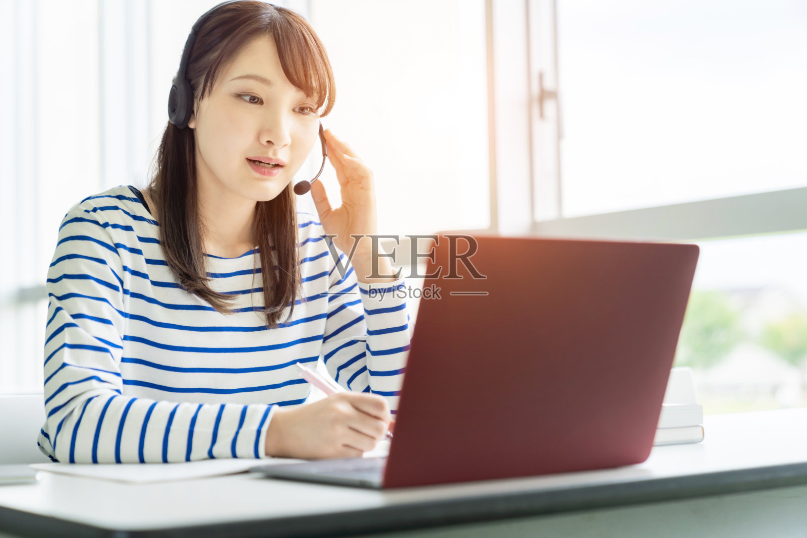 正在上在线课程的亚洲女学生。电子学习。远程工作。照片摄影图片