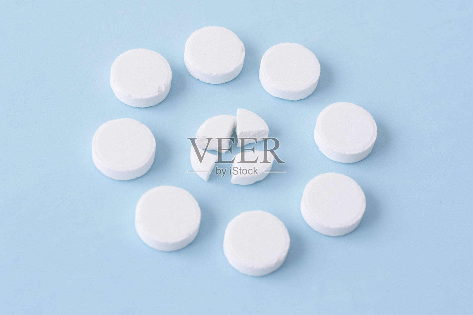 蓝色背景上的白色圆形药丸。健康的概念照片摄影图片