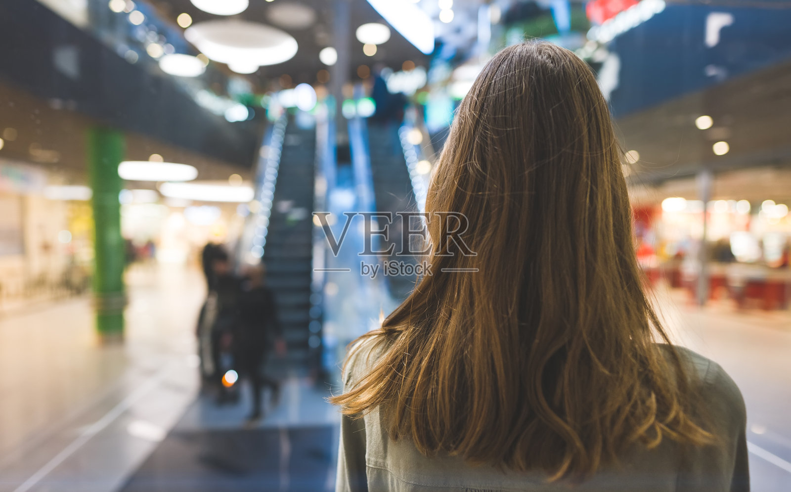 大型购物中心电梯里的女孩。照片摄影图片