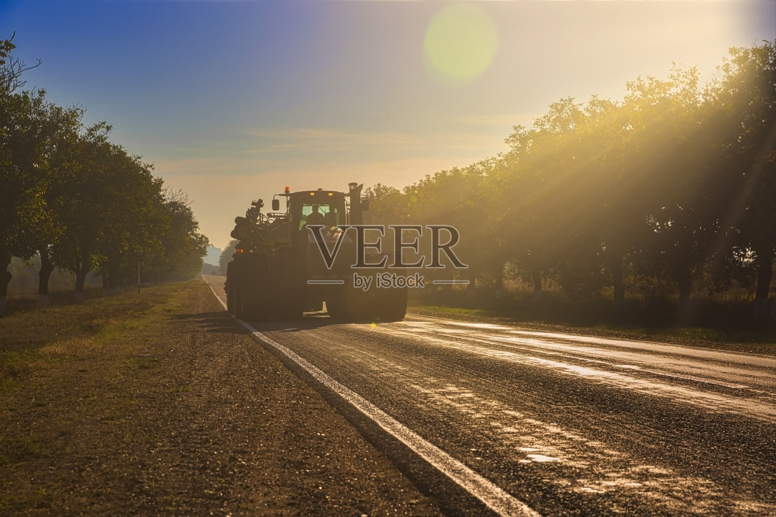 农用拖拉机收割完田地正返回路上照片摄影图片