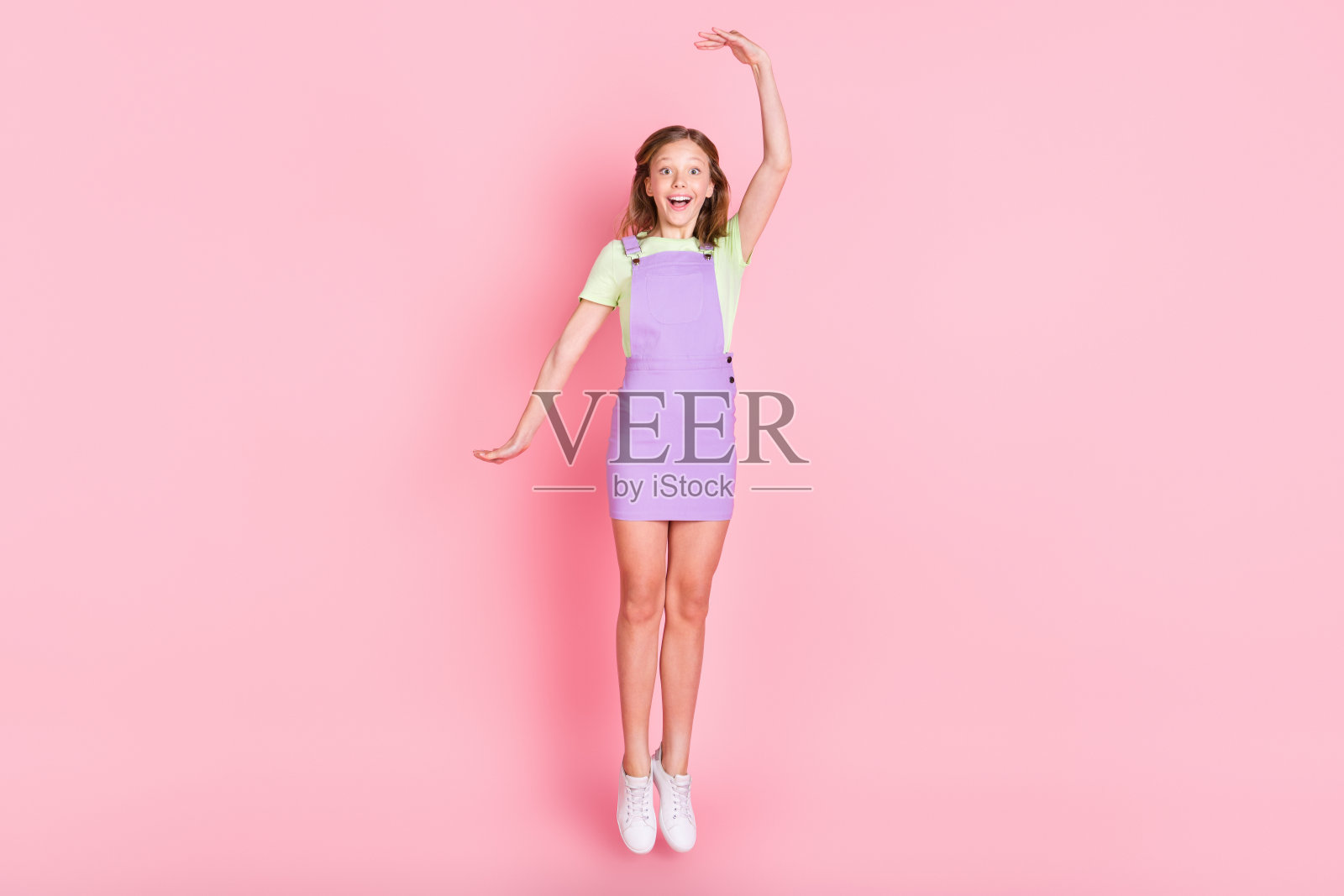 全身大小的照片小女孩跳高显示生长微笑孤立的淡粉色背景照片摄影图片