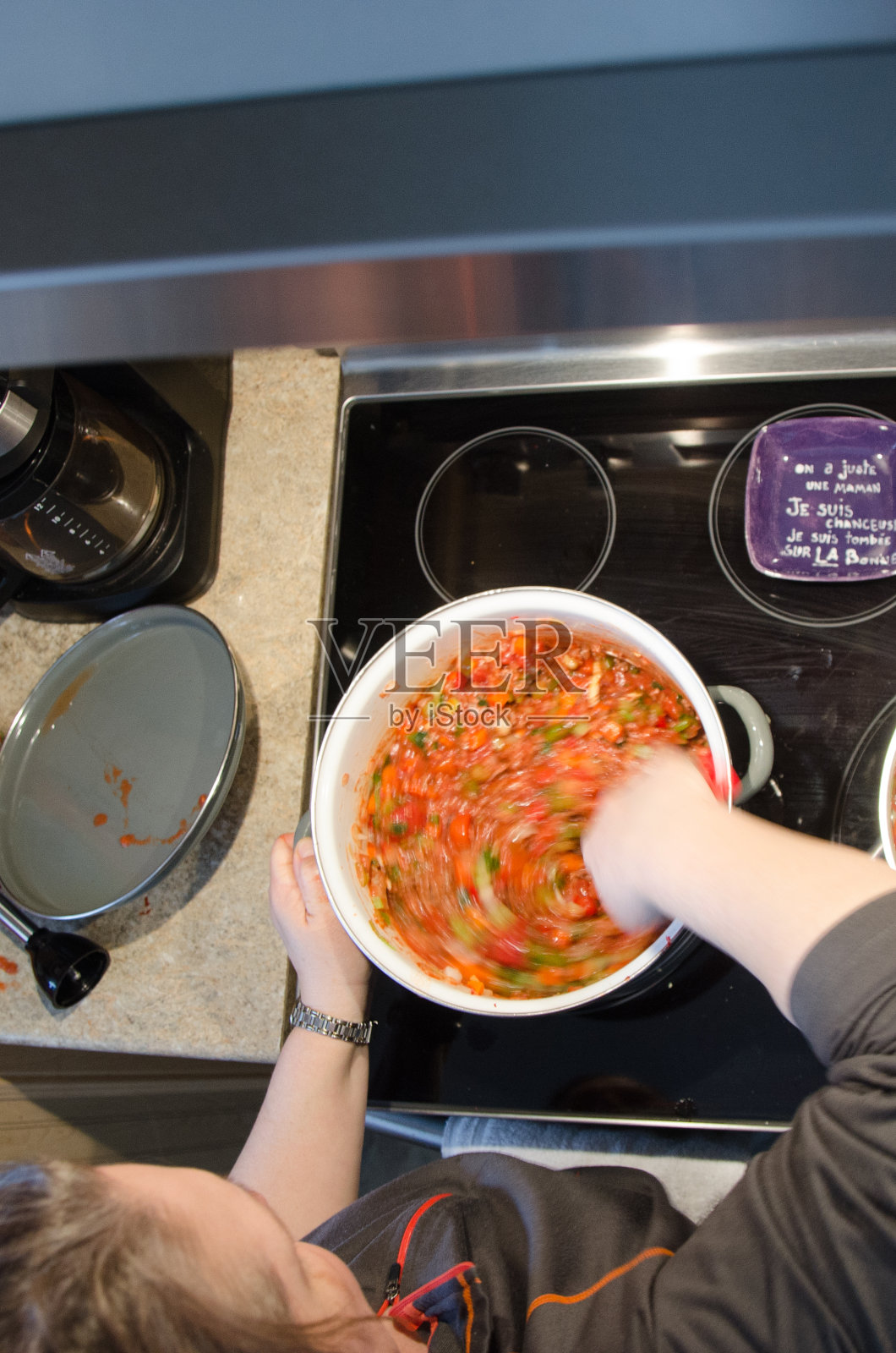 一个女人在烤箱上煮意大利面酱照片摄影图片