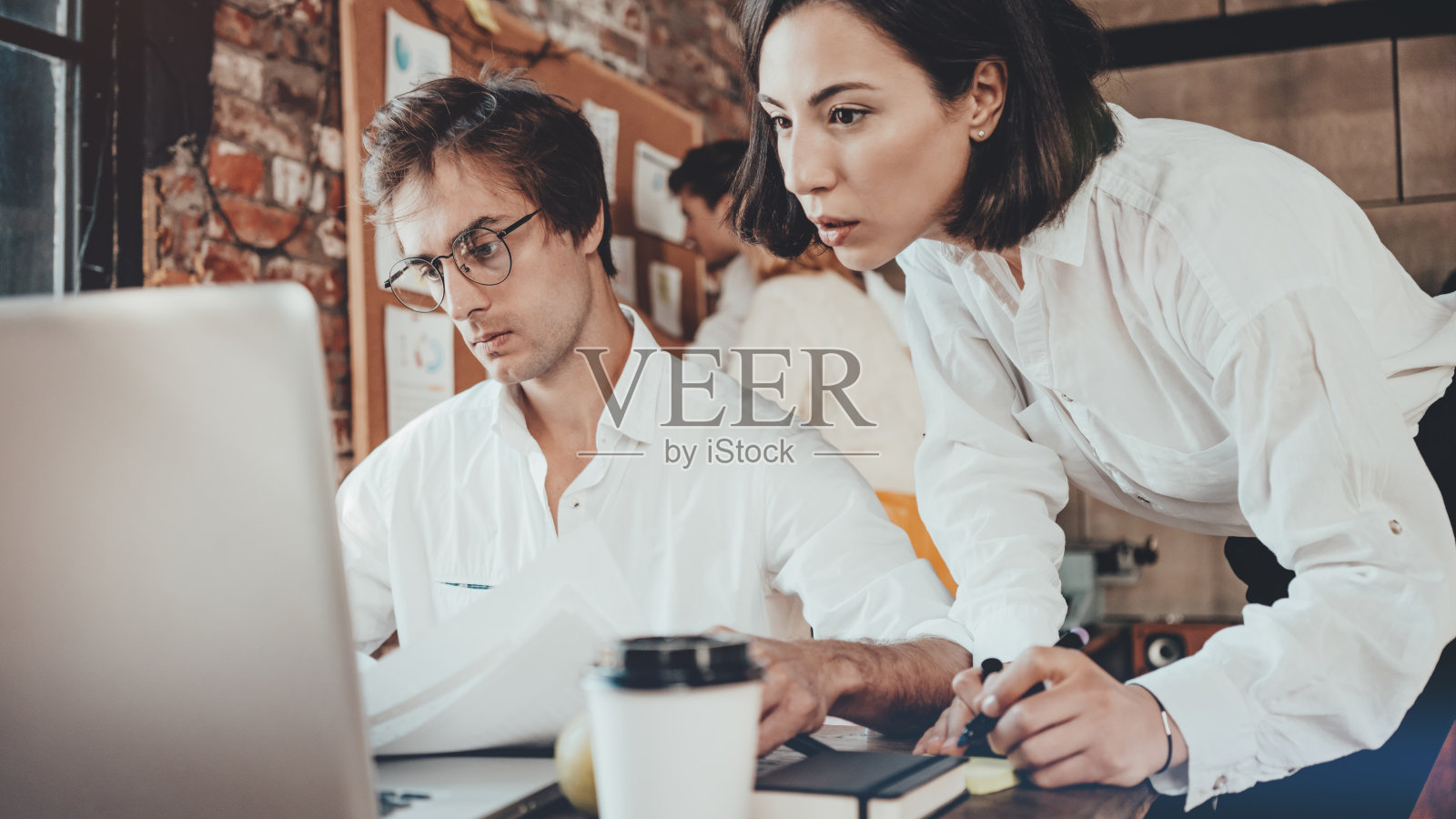 办公室业务概念。女人和男人一起工作，用笔记本电脑解决营销任务照片摄影图片