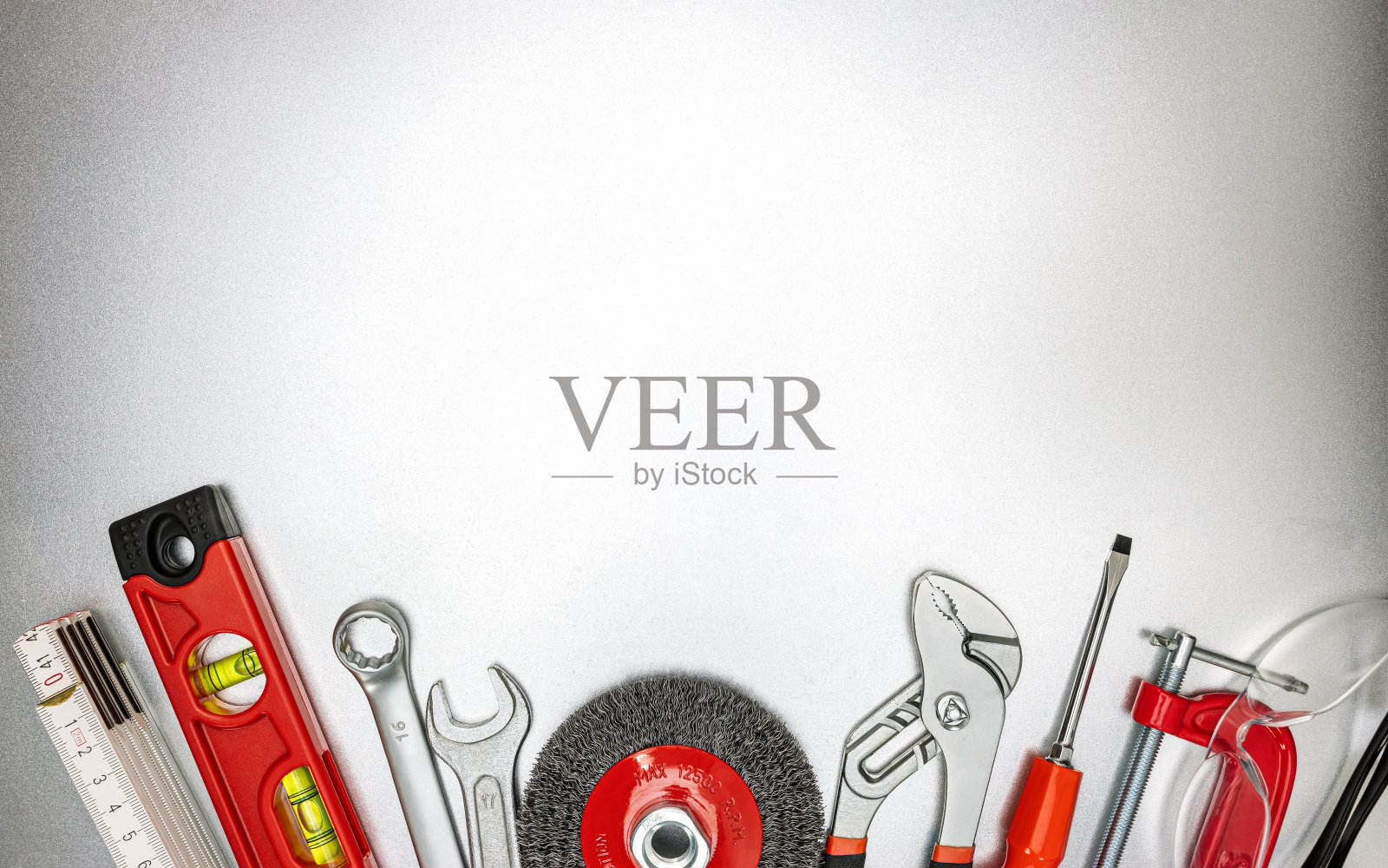 灰色金属桌子上摆放着各种装修工具和工作工具。俯视图照片摄影图片