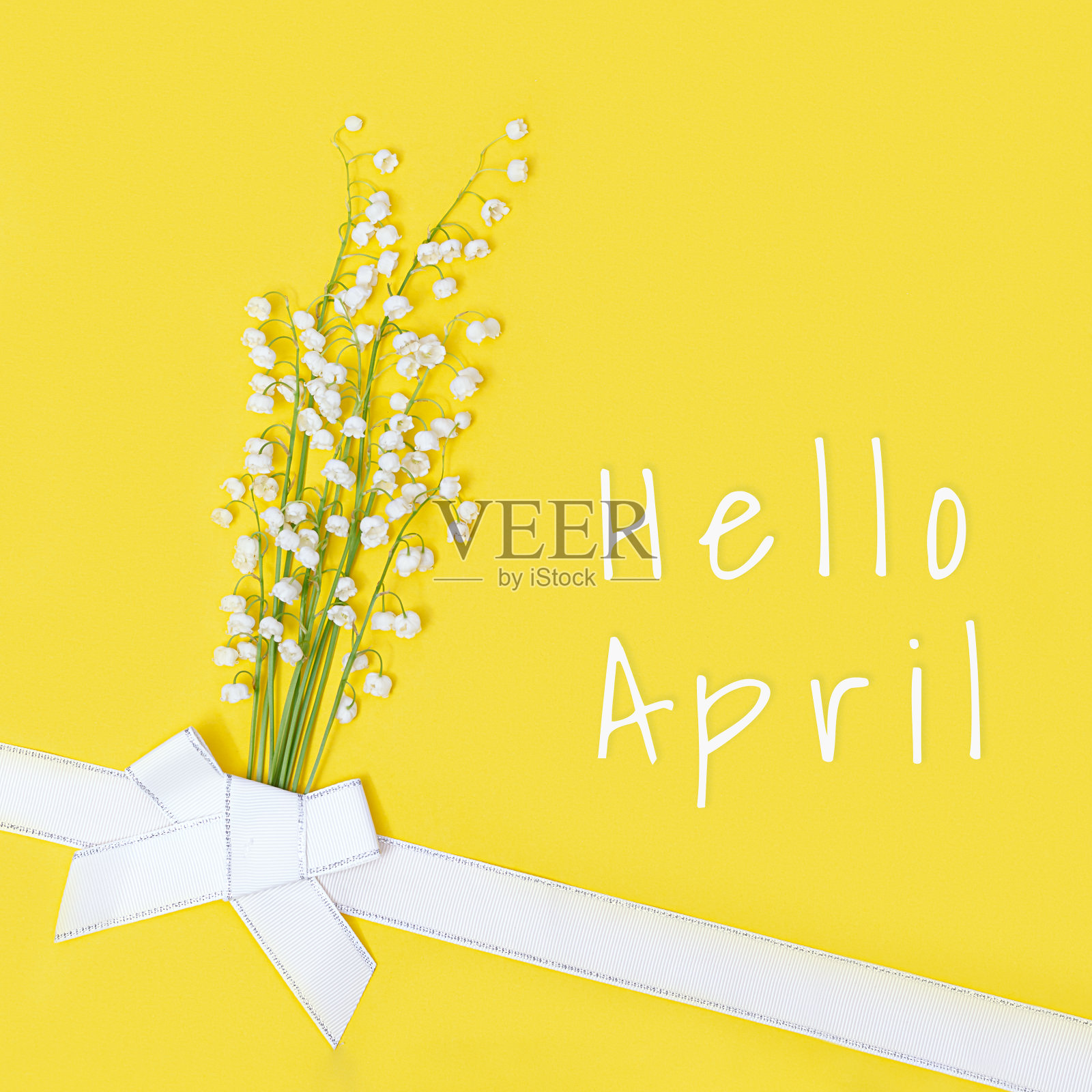 创造性的平面构图与春天的花和山谷的百合。平铺花卉设计和标题你好四月。照片摄影图片