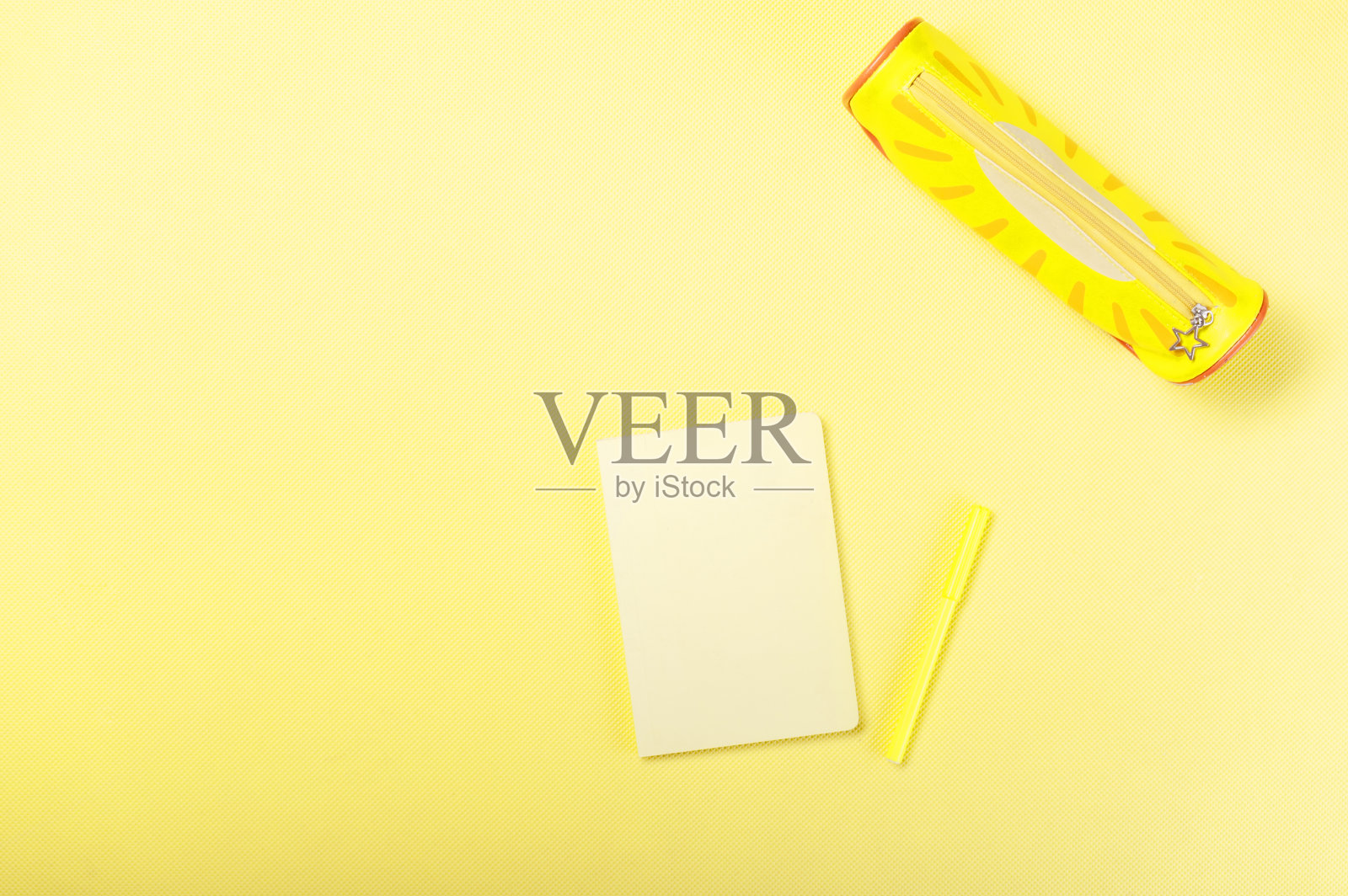 黄色的记事本放在黄色的桌子上。黄色的项目。黄色的办公室。上面。照片摄影图片