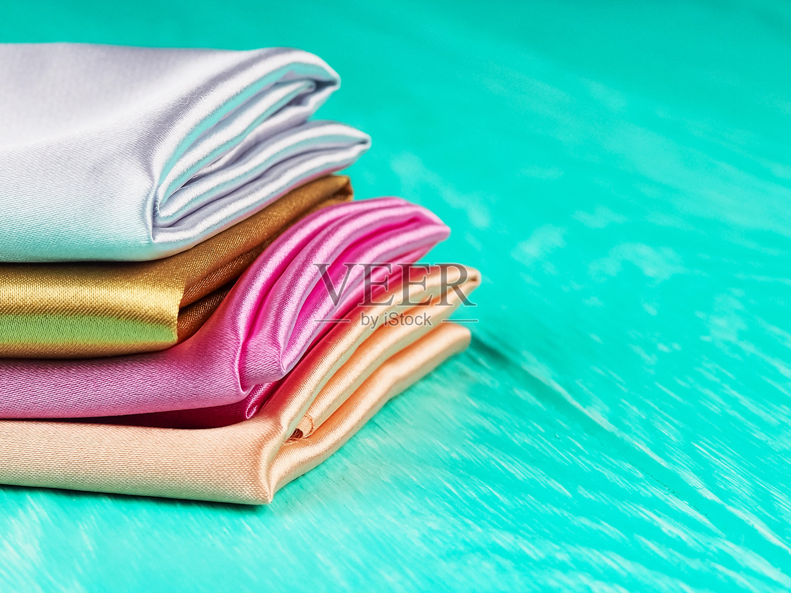 一堆多色缎子织物上的蓝色背景，文字空间照片摄影图片