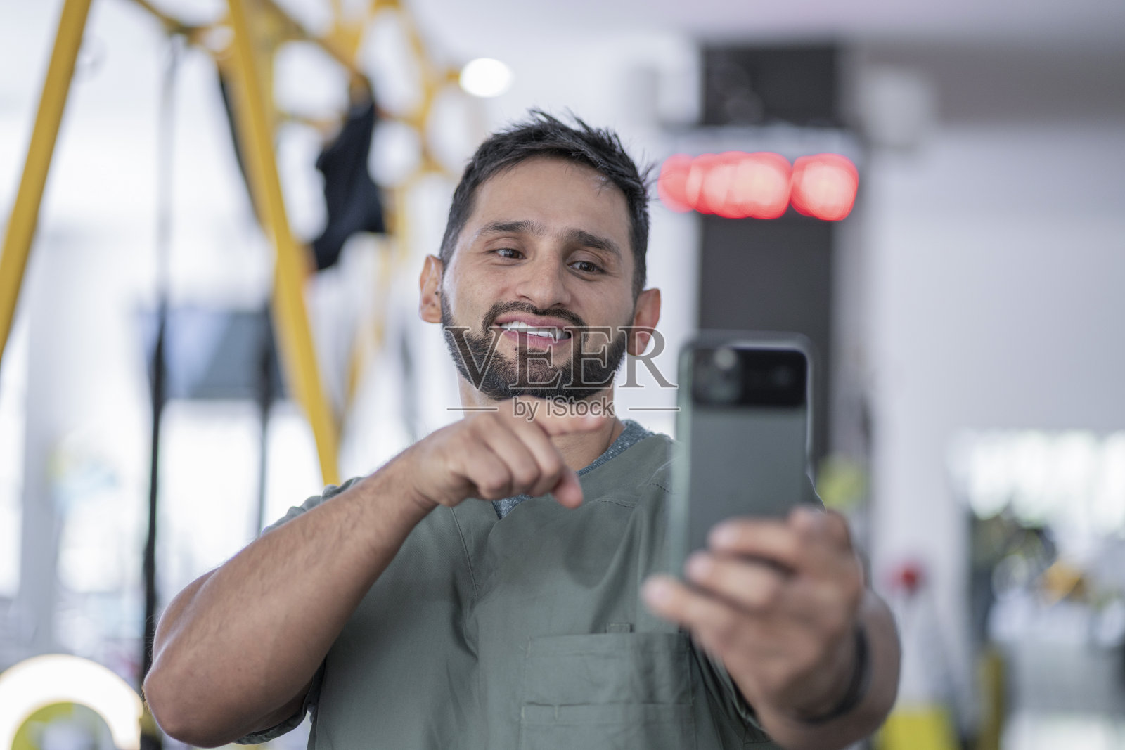 一个在健身房的拉丁理疗师用他的手机与他的路人进行视频通话照片摄影图片