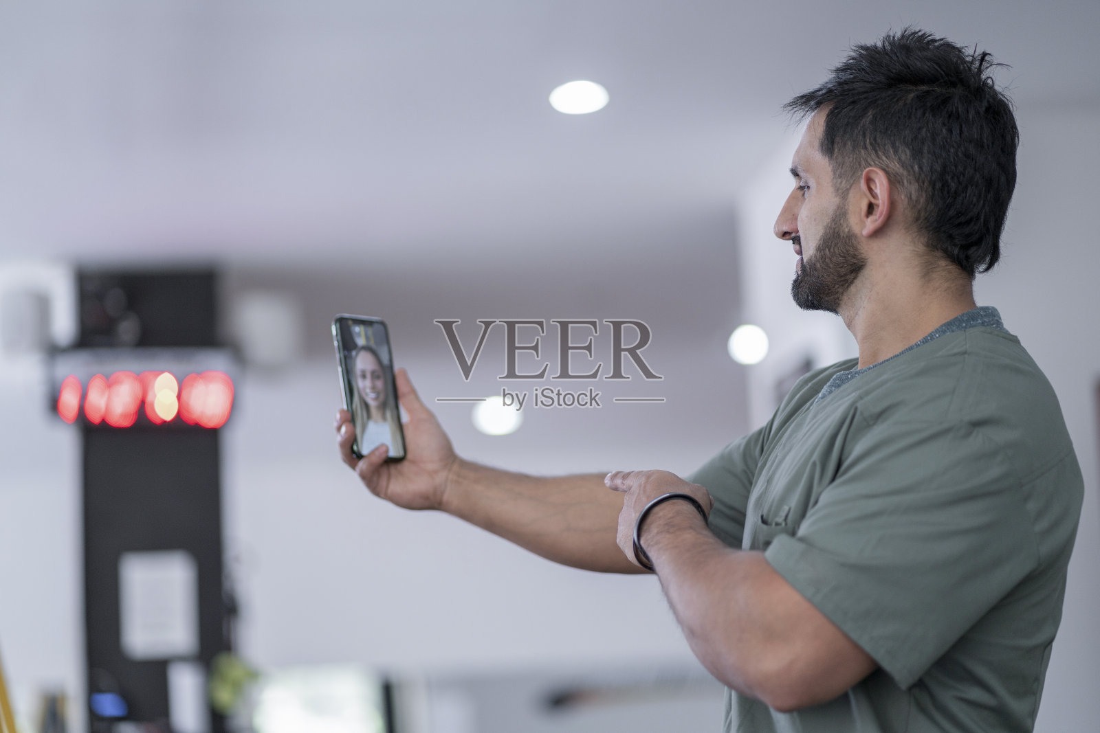 一个在健身房的拉丁理疗师用他的手机与他的路人进行视频通话照片摄影图片