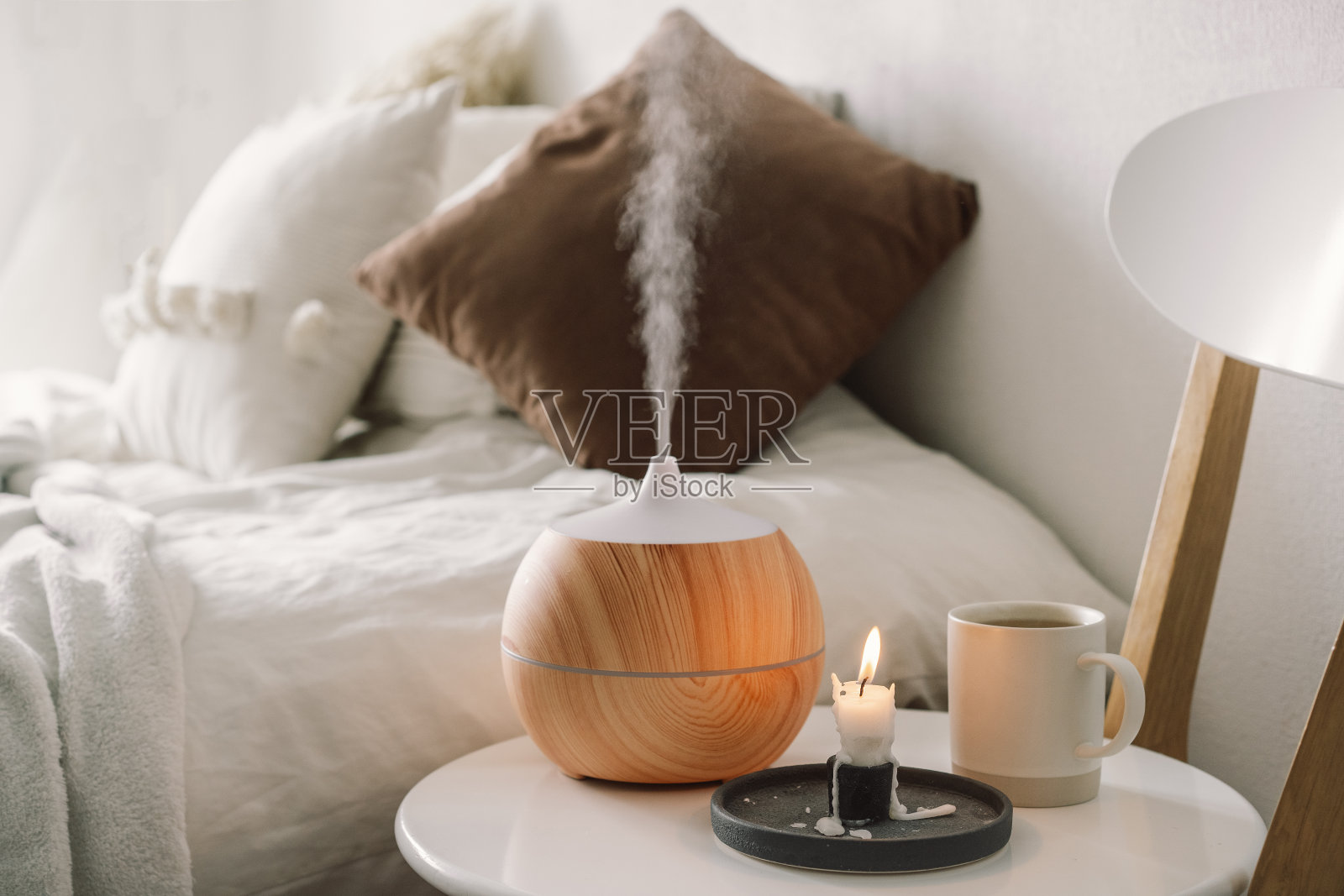 卧室椅子上靠香油扩散器。照片摄影图片