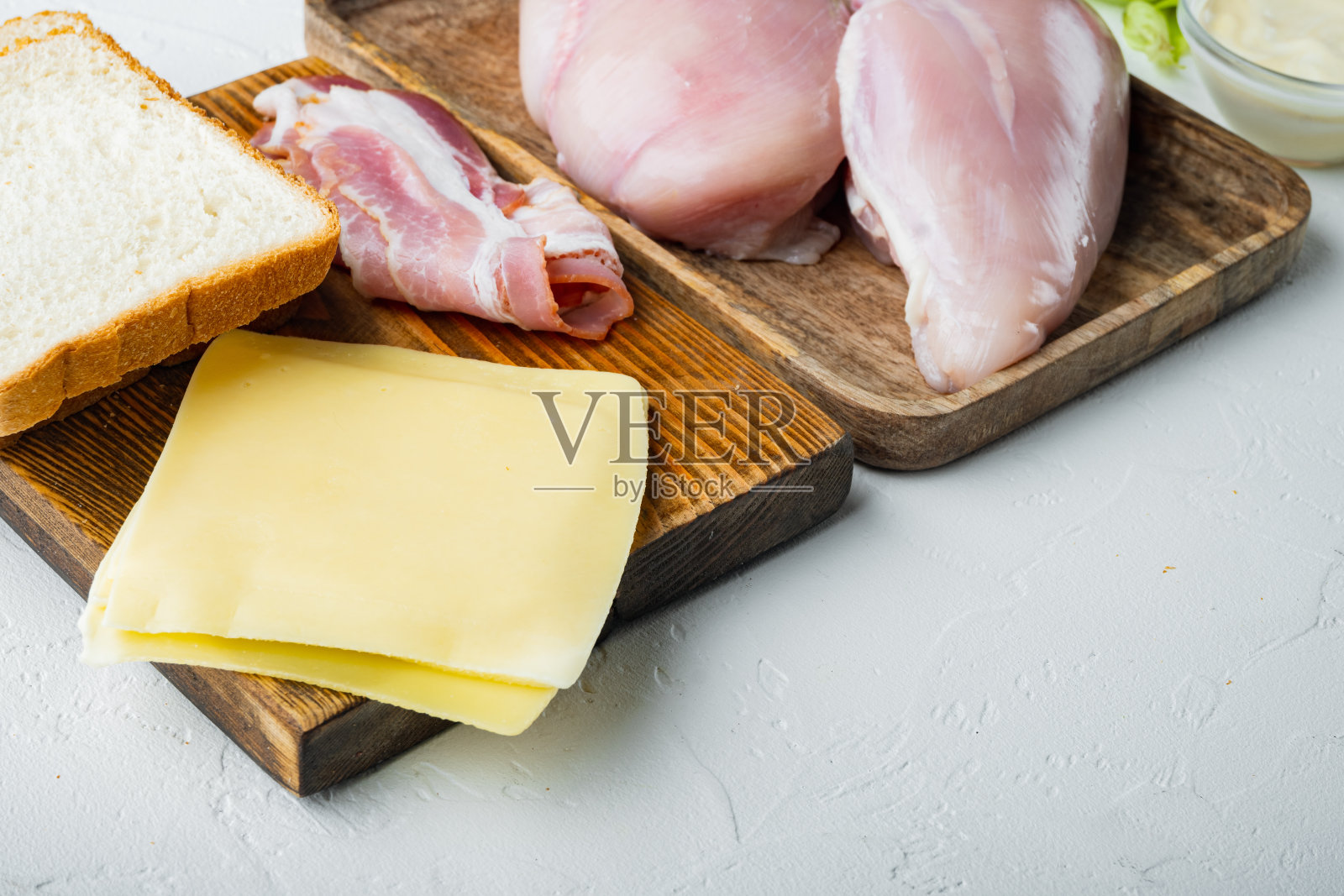 制作三明治，培根，奶酪，番茄，鸡肉，生菜，酱汁，白色背景，空白文字照片摄影图片