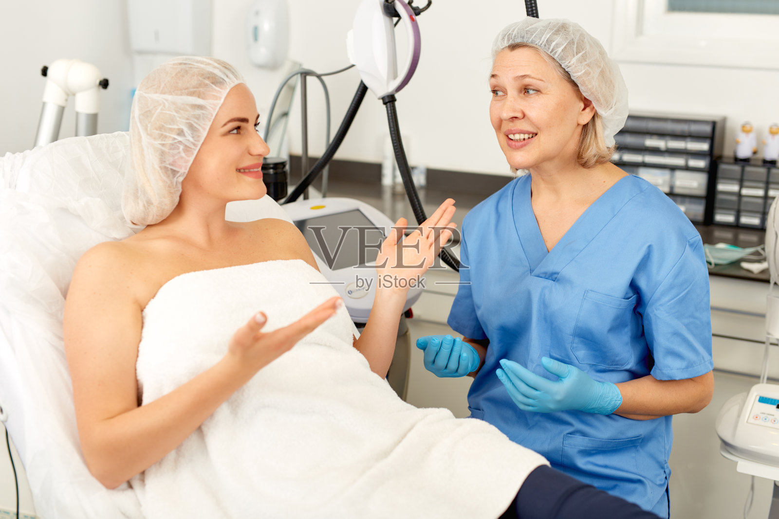 美容师在诊所与女士讨论美容程序照片摄影图片