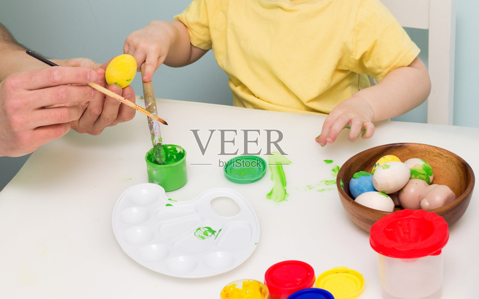 儿童着色木蛋。的家人复活节活动。传统节日装饰。美术器材油漆、调色板、刷子照片摄影图片
