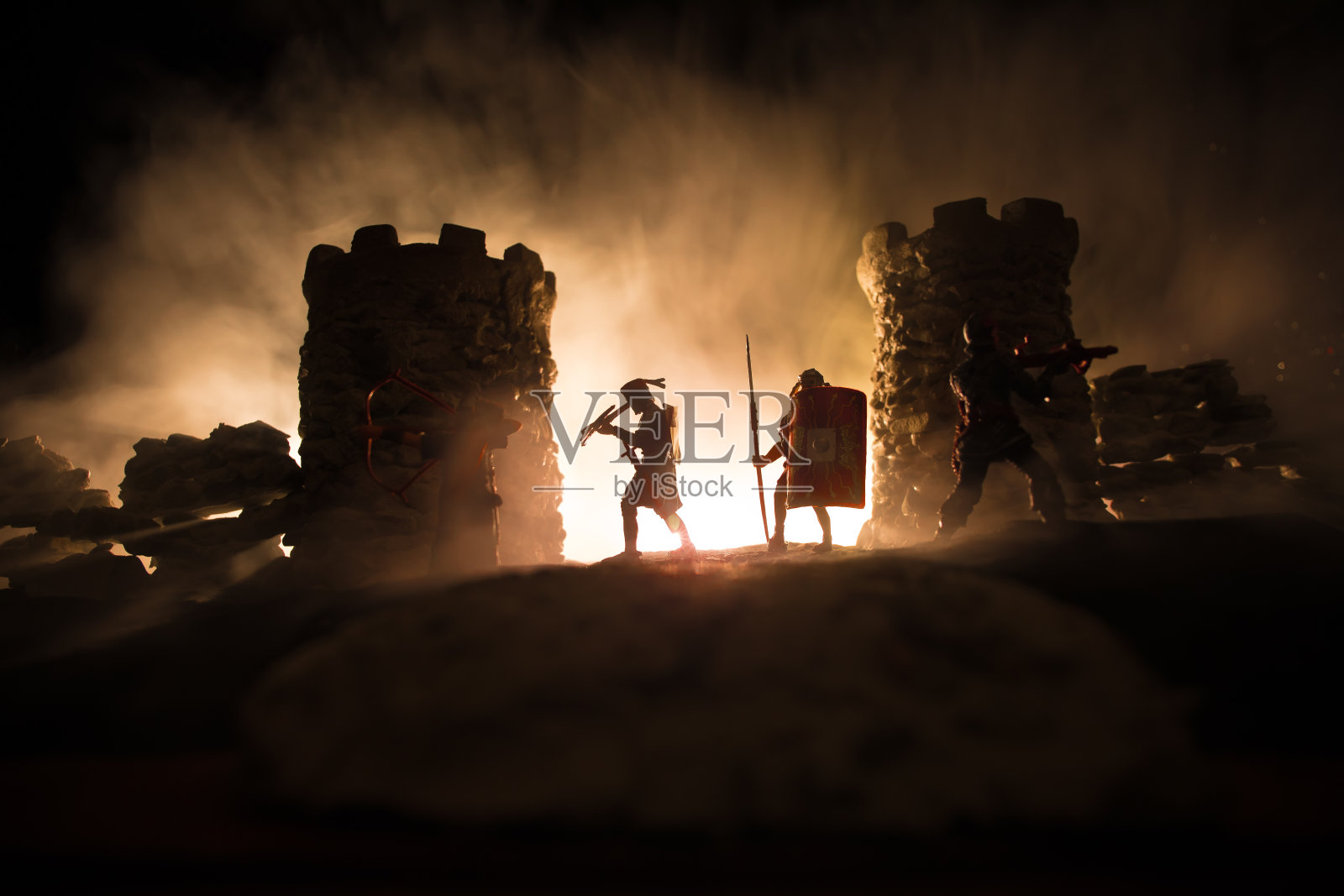 中世纪的战斗场景。剪影的人物作为单独的对象，战士之间的战斗在晚上。创意艺术品装饰。雾蒙蒙的背景。照片摄影图片