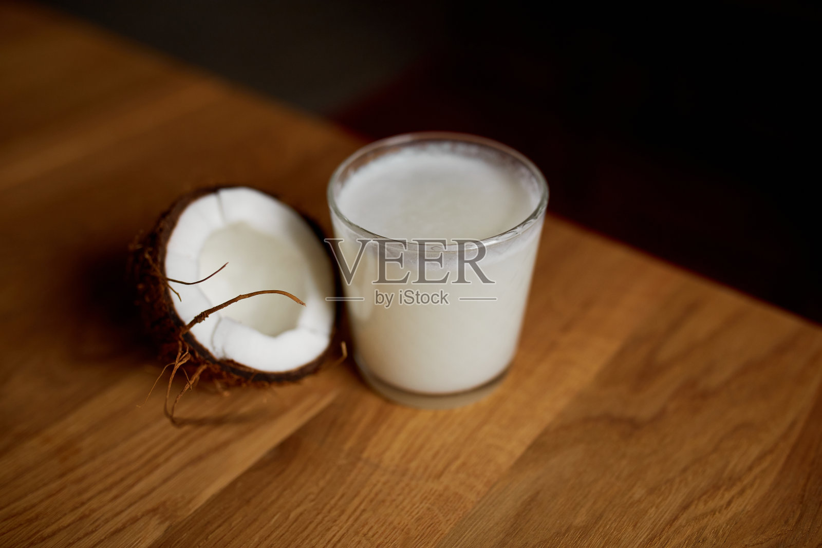 新鲜健康的椰子汁在一个玻璃杯在木桌的背景照片摄影图片