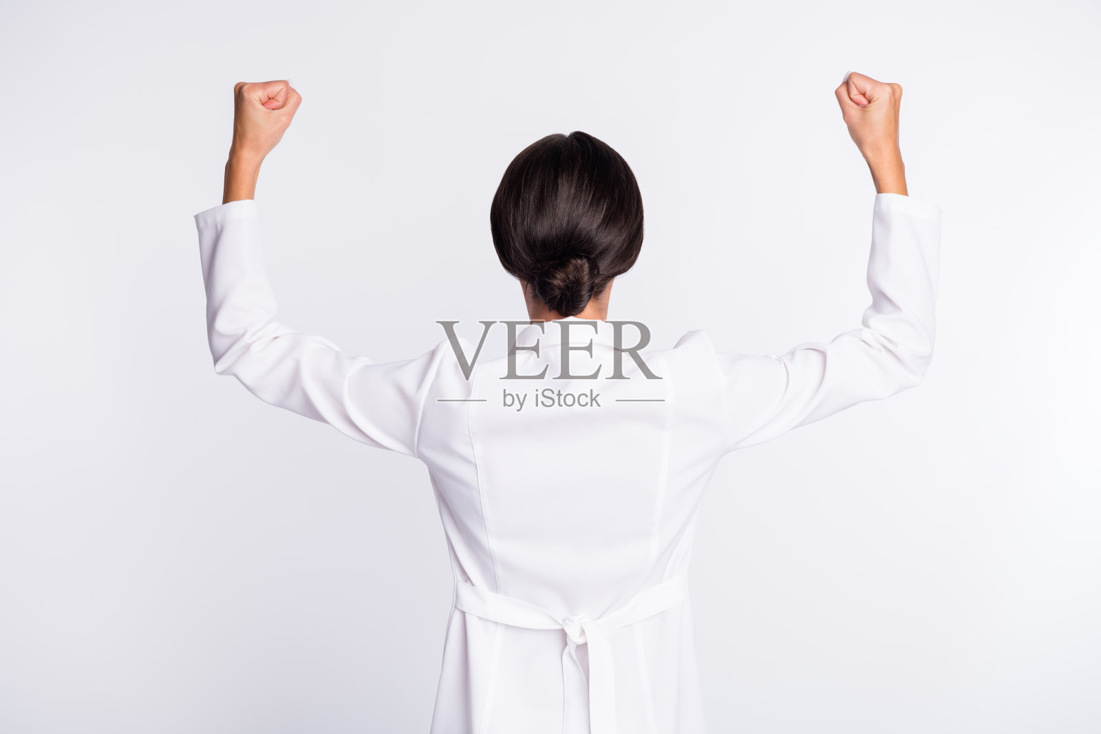 照片漂亮苗条的年轻女士医生背穿制服，升起的拳头孤立的白色背景照片摄影图片