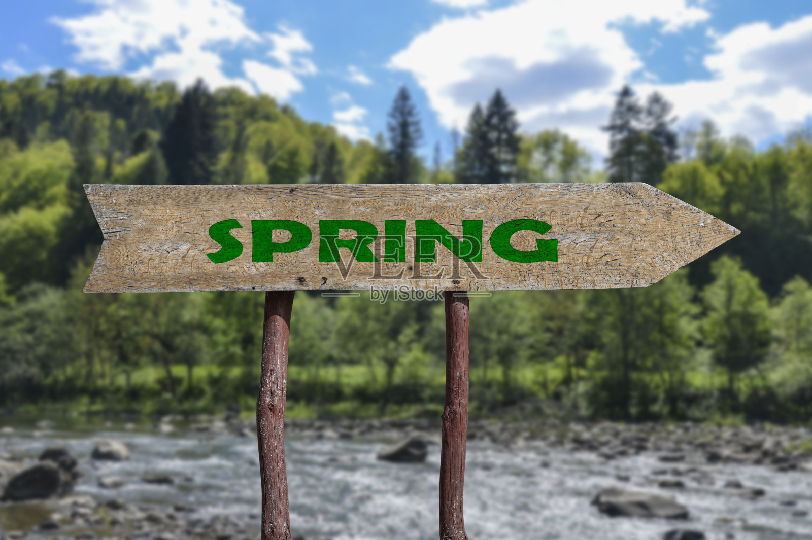 春天的木箭路牌映衬着河流和森林的背景。春天美丽的大自然。照片摄影图片