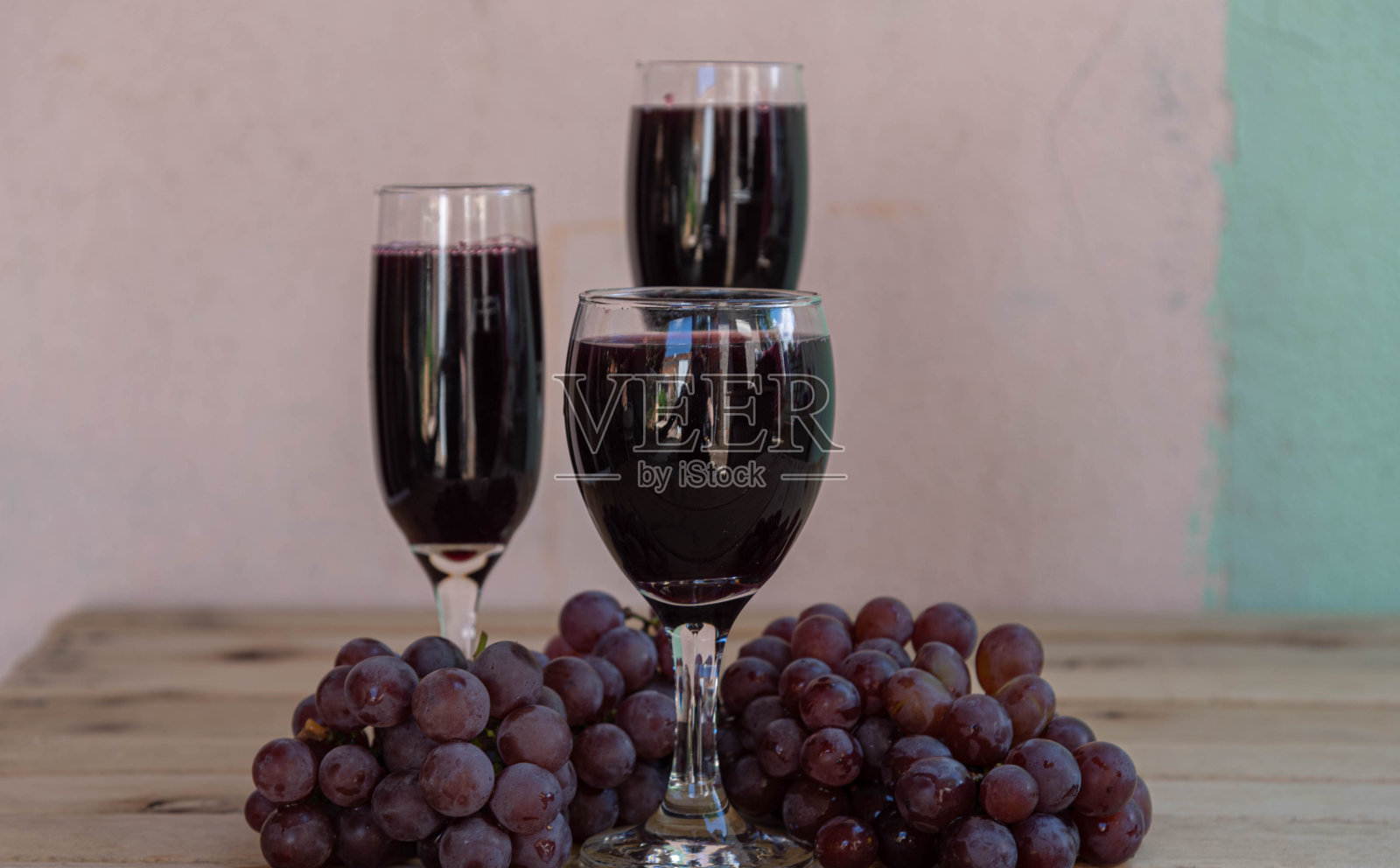 碗，葡萄汁和新鲜的葡萄在木质表面照片摄影图片