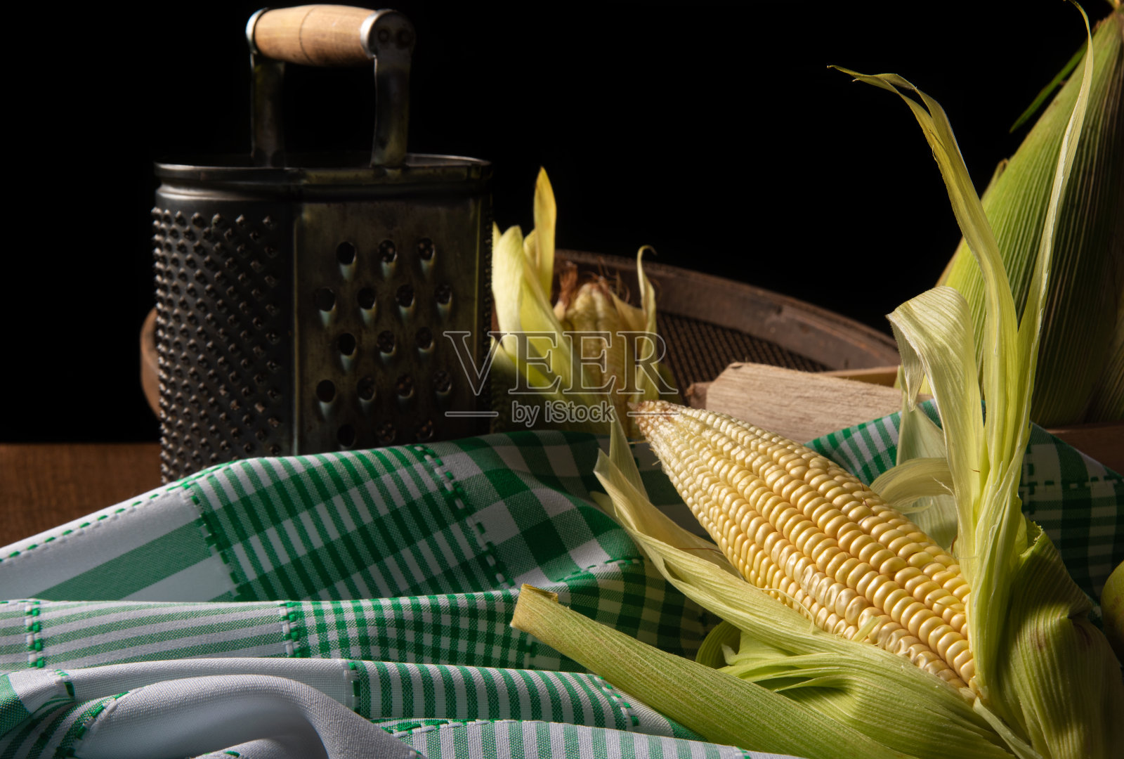 在巴西的Festa Junina，绿玉米，研磨器和筛子在桌子上，选择性的焦点。照片摄影图片