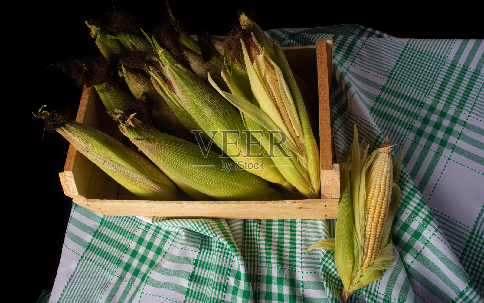 巴西朱尼纳节日，绿色的玉米在一个木盒子里的桌子上，俯视图。照片摄影图片