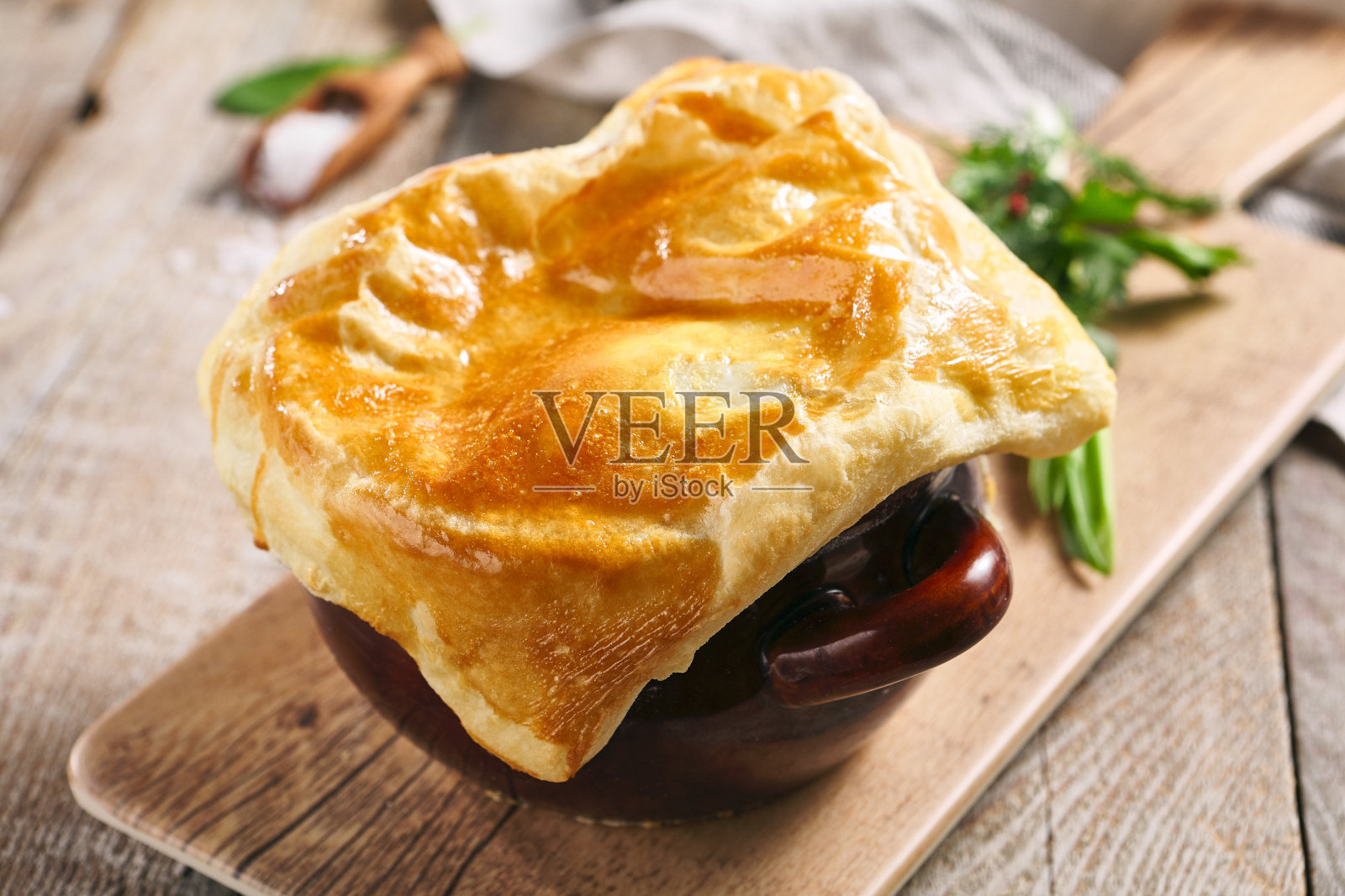 蘑菇汤配面包。美味的食物在棕色的锅在木桌上。乡村风格的食物。照片摄影图片