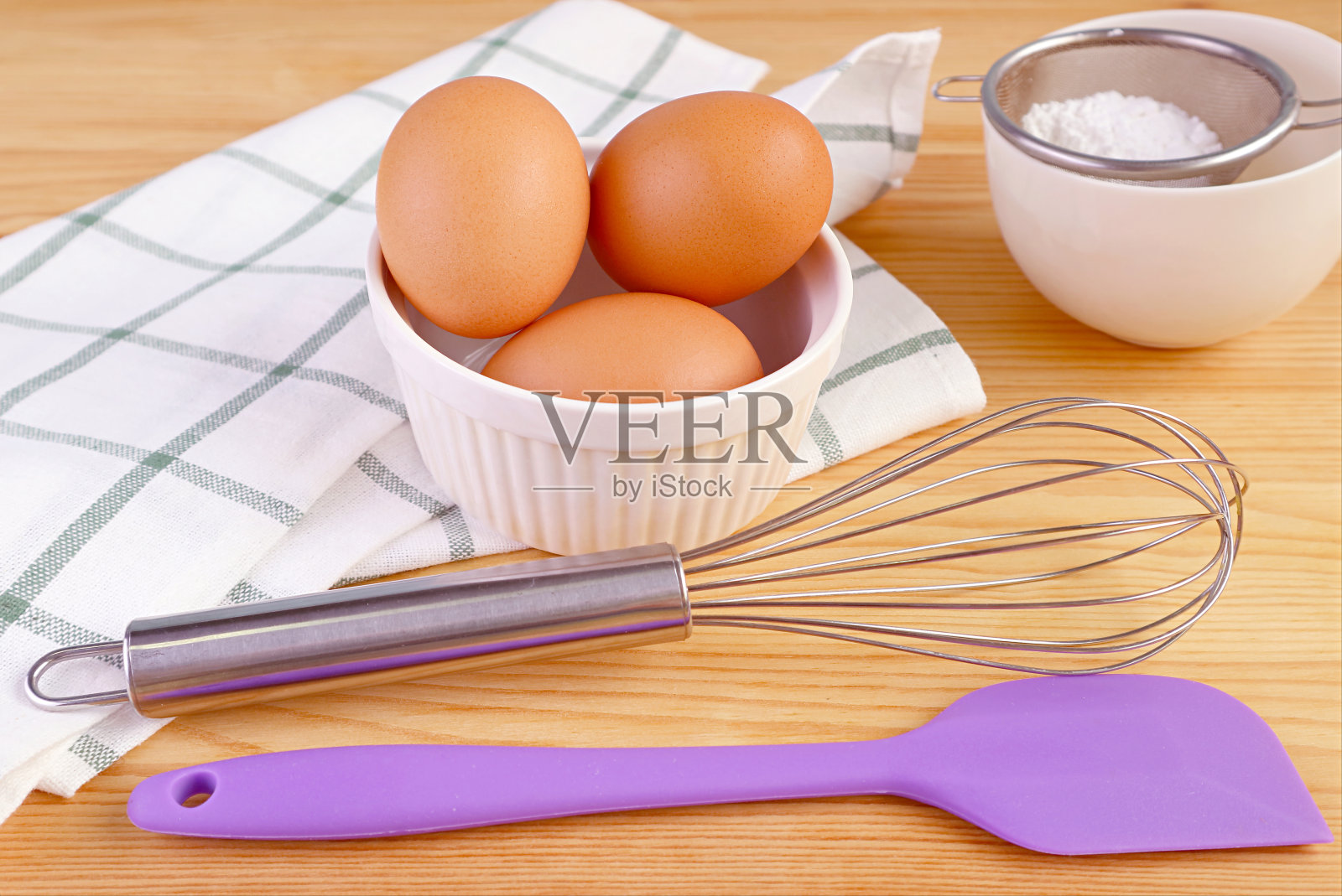鸡蛋与搅拌器和厨房用具放在木桌上，用于家庭烹饪照片摄影图片