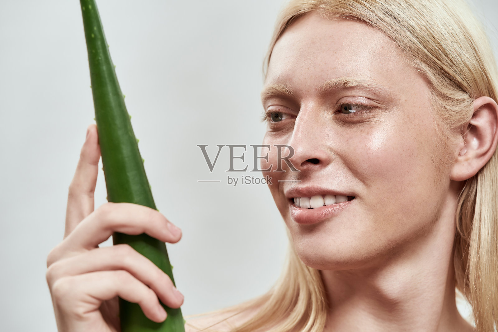 一个年轻人看着芦荟叶的肖像照片摄影图片