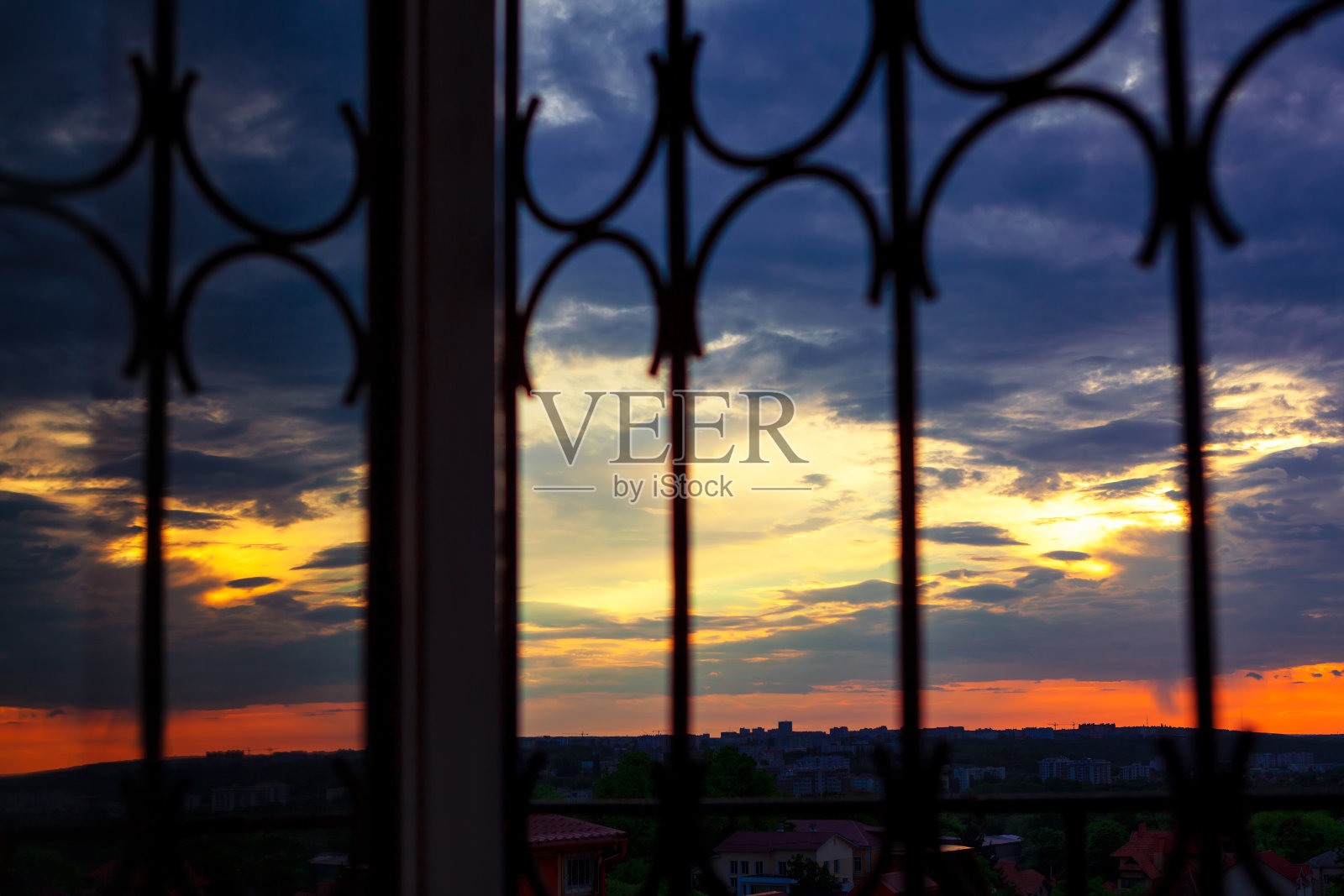 夕阳透过窗户的铁栅栏照片摄影图片