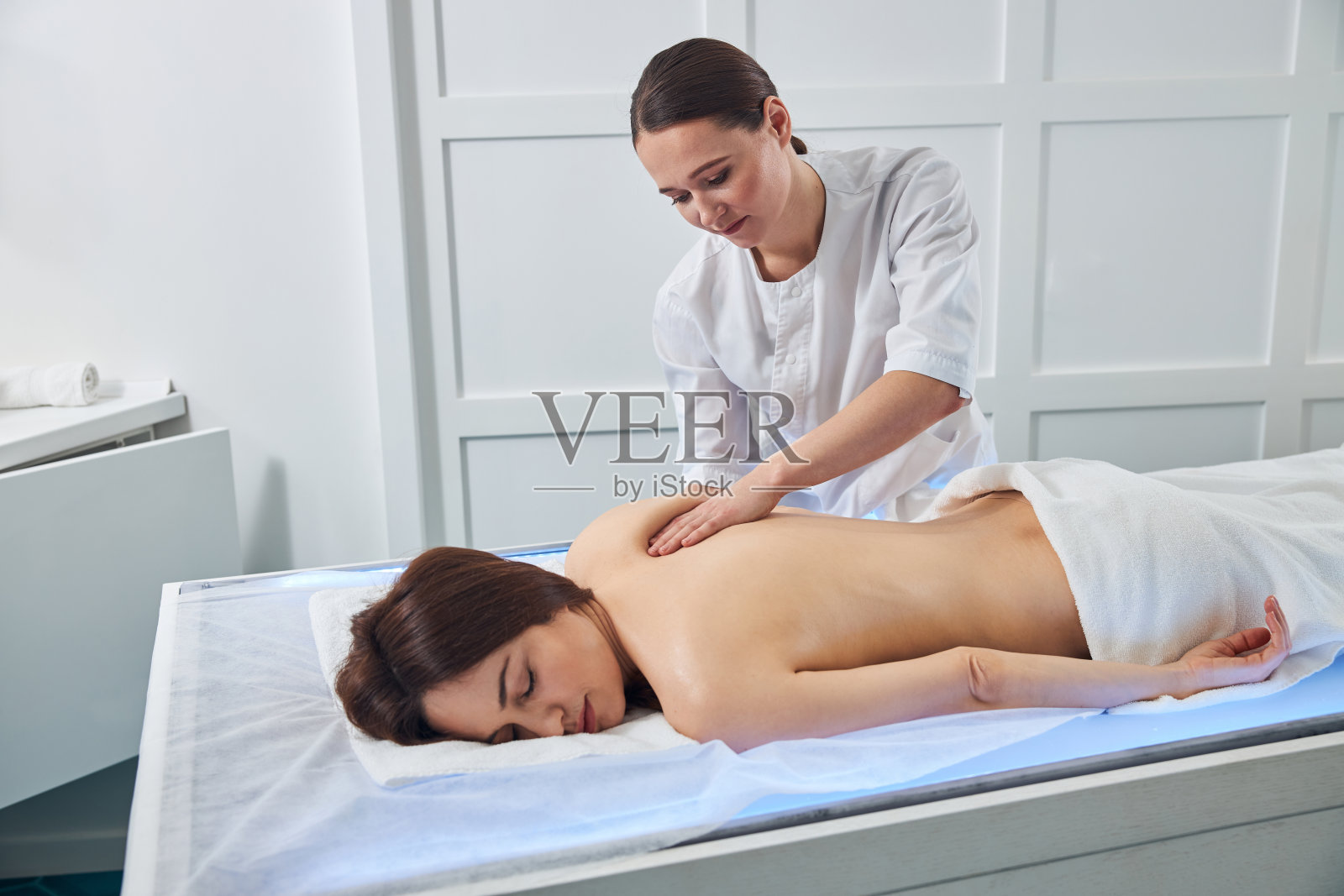 女按摩师用手掌揉肩部皮肤照片摄影图片