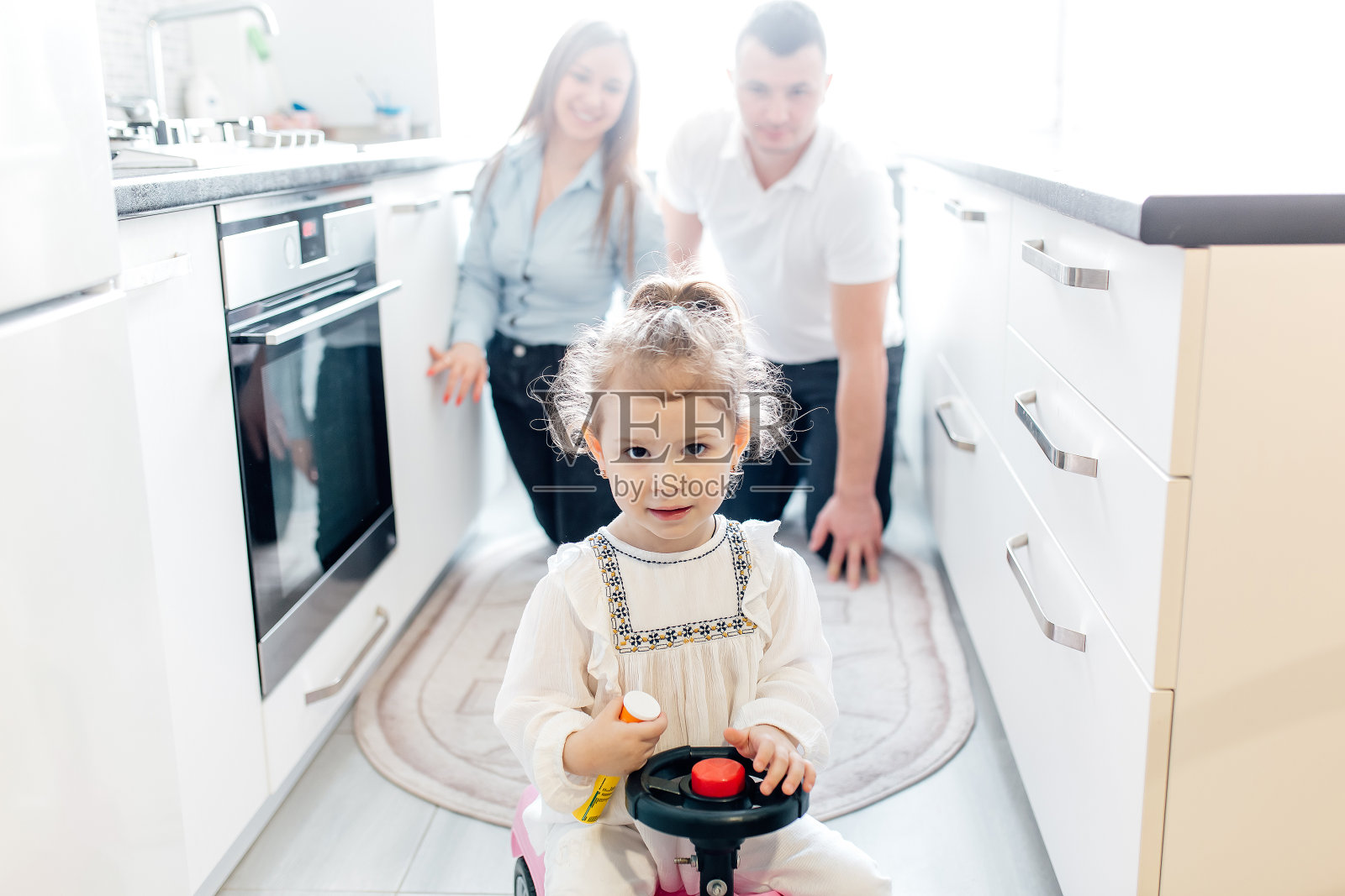 爸爸妈妈和他们的小女儿在厨房里玩得很开心照片摄影图片