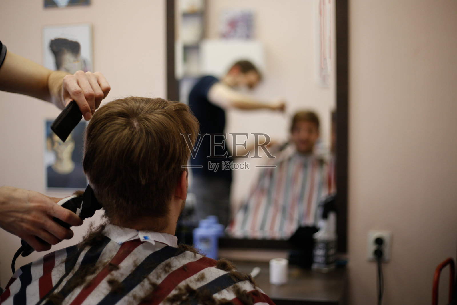 冠状病毒大流行期间，一名男子戴着口罩在理发店理发照片摄影图片