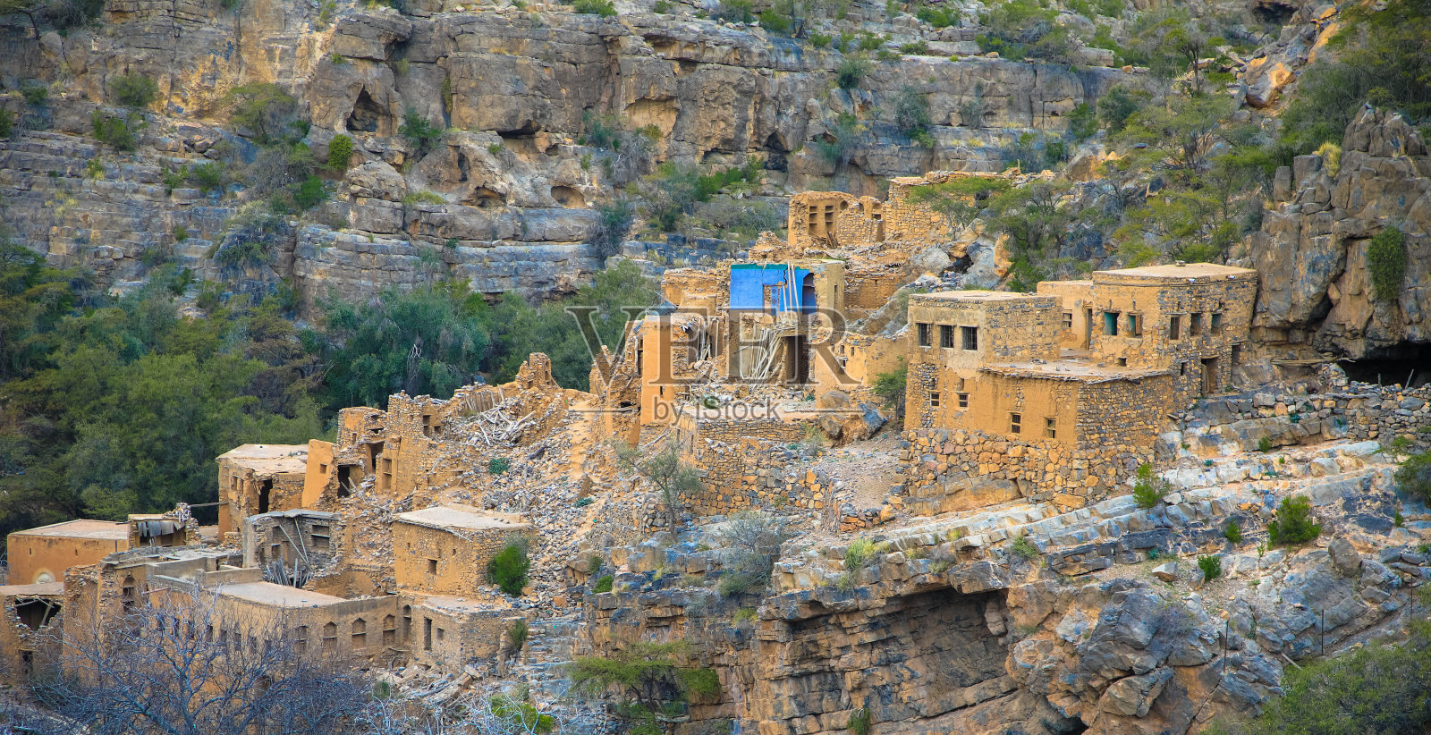 阿曼瓦迪纳克尔入口处古老废弃的Ghul村庄全景，含农田照片摄影图片