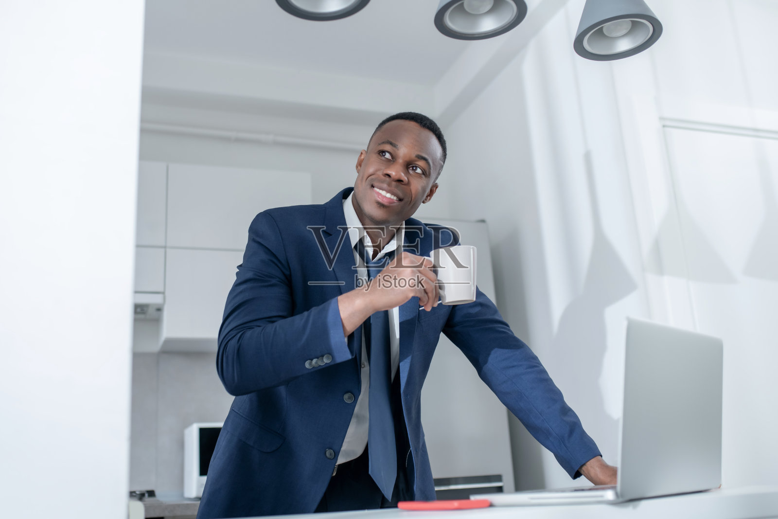 优雅的黑皮肤男子站在一杯咖啡和微笑照片摄影图片