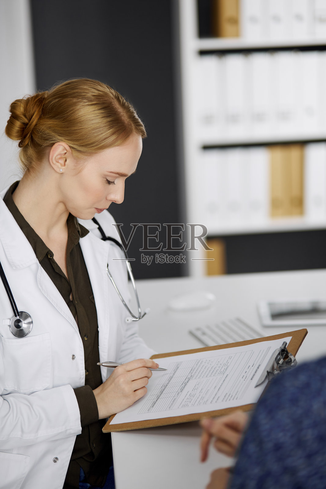 友好微笑的女医生和病人妇女讨论当前的健康检查，而坐在诊所。医疗保健理念照片摄影图片