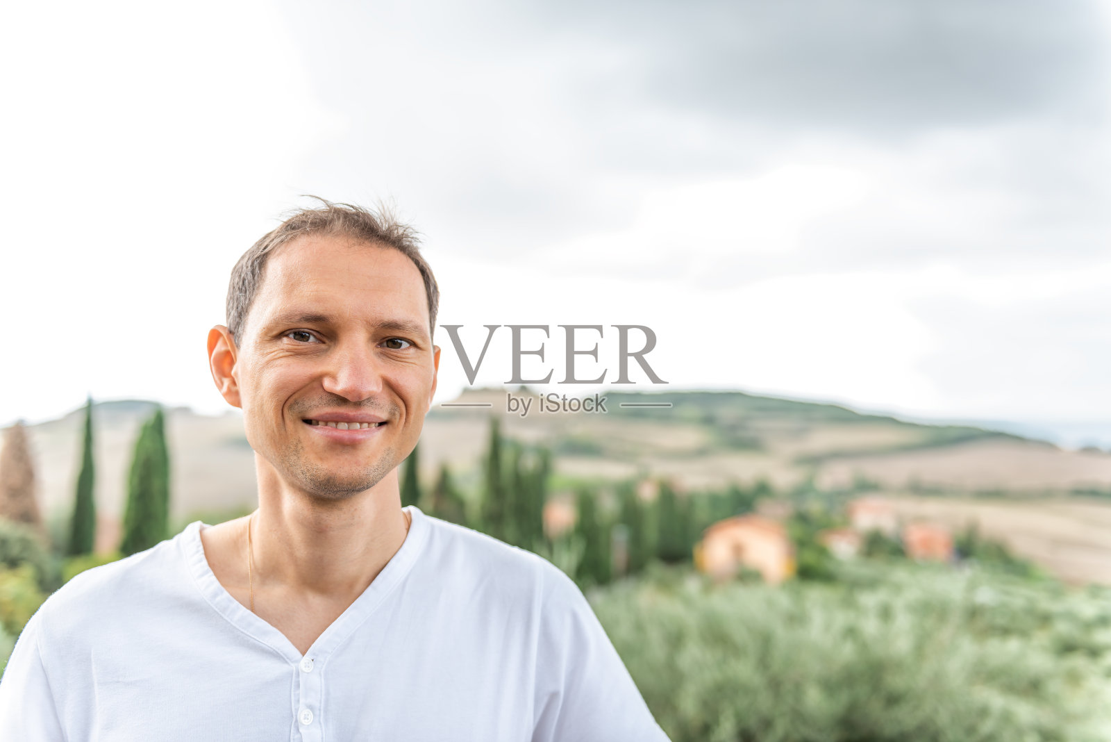 Monticchiello, Val D'Orcia乡村村庄在托斯卡纳，意大利与滚动绿色的山与农场景观田园诗如画的草地和快乐的年轻人农民照片摄影图片