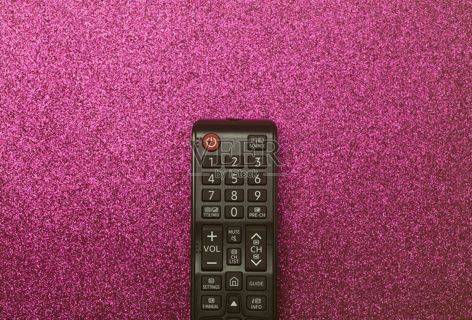 电视遥控器的背景是粉色的闪光。电影、娱乐、电视概念。照片摄影图片