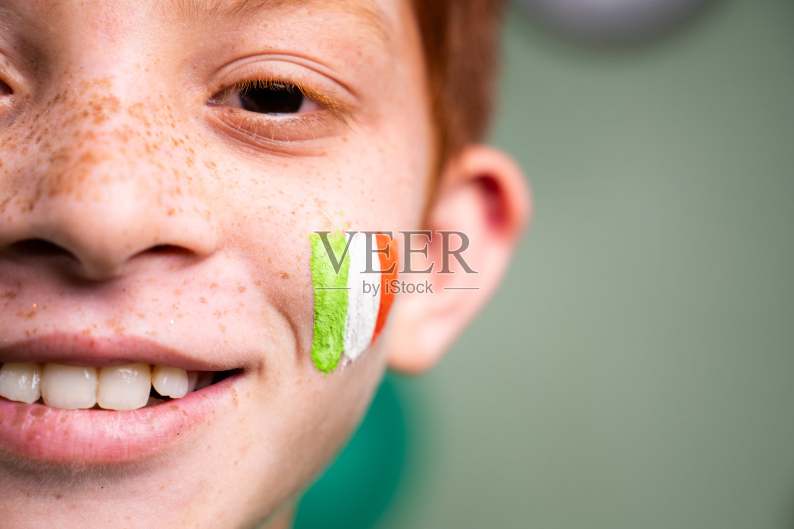 微笑的孩子与圣帕特里克节三色旗爱尔兰在节日庆祝与复制空间的孩子的脸的特写照片摄影图片