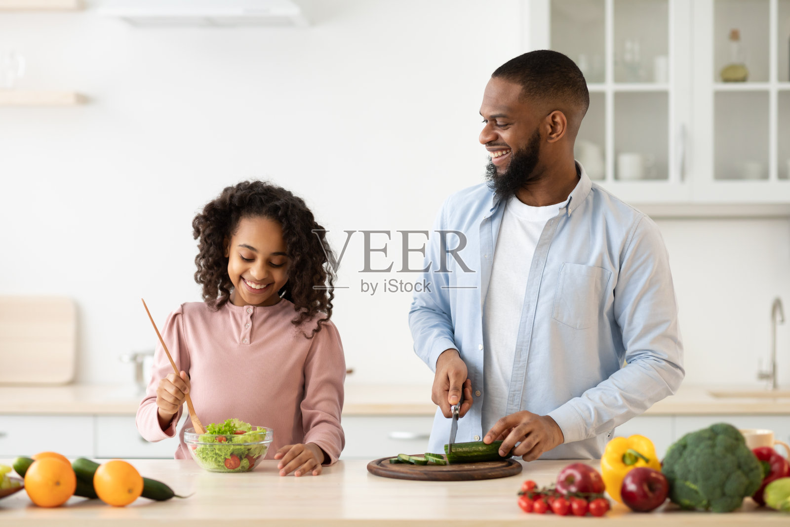 非裔美国人父亲和女儿在做沙拉照片摄影图片
