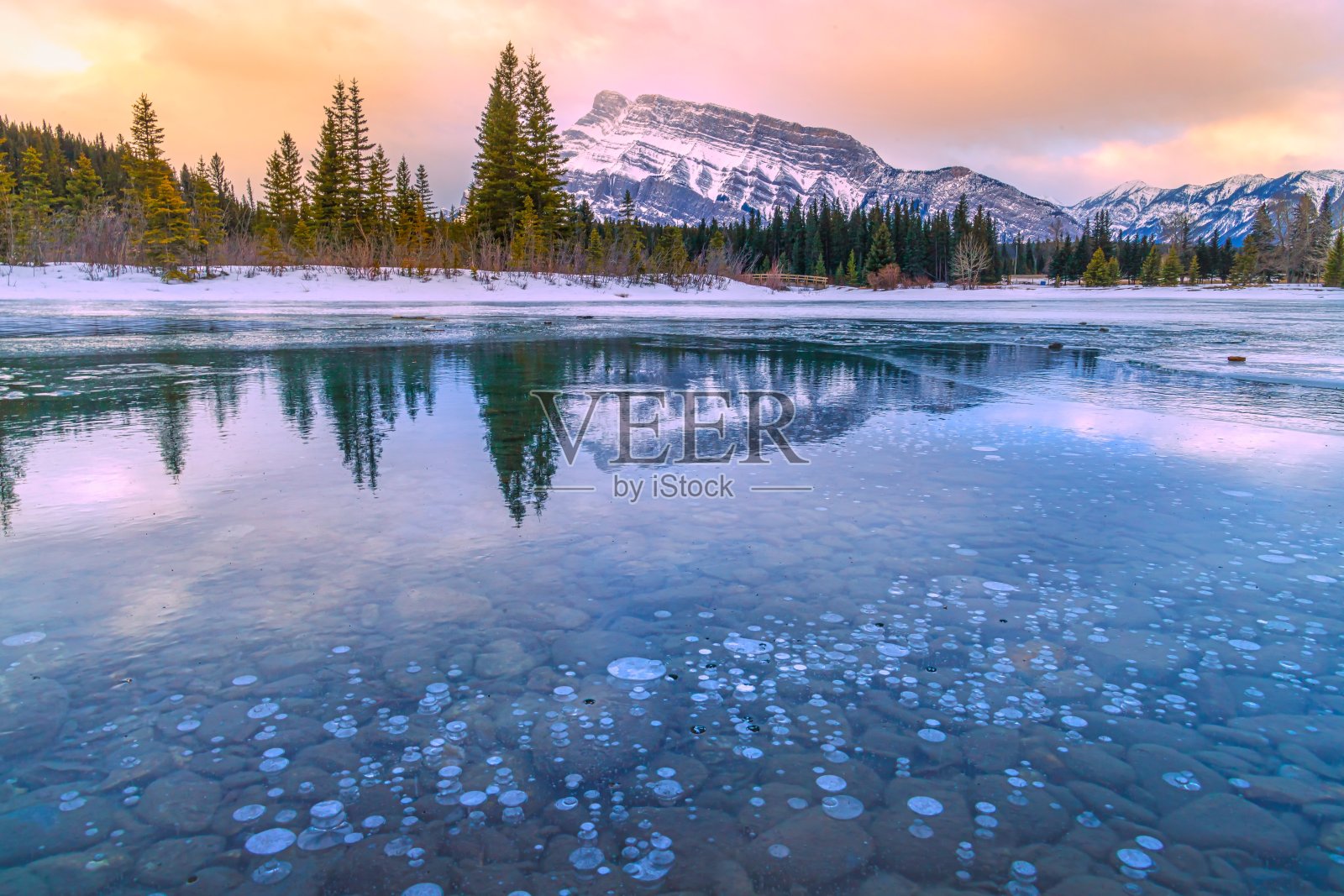 日出倒映在结冰的小池塘里照片摄影图片