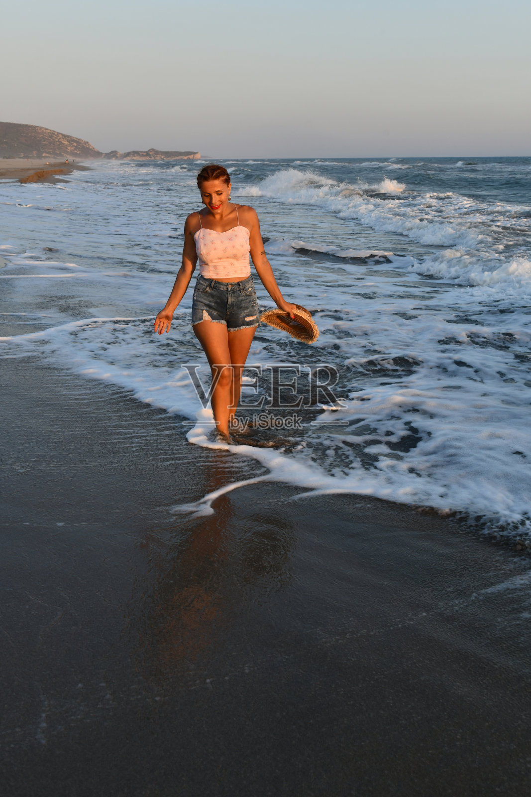 在海滩上玩得开心的女人。照片摄影图片