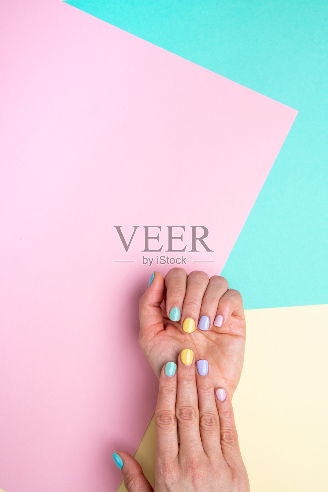 彩色背景上涂上柔和的指甲油。照片摄影图片