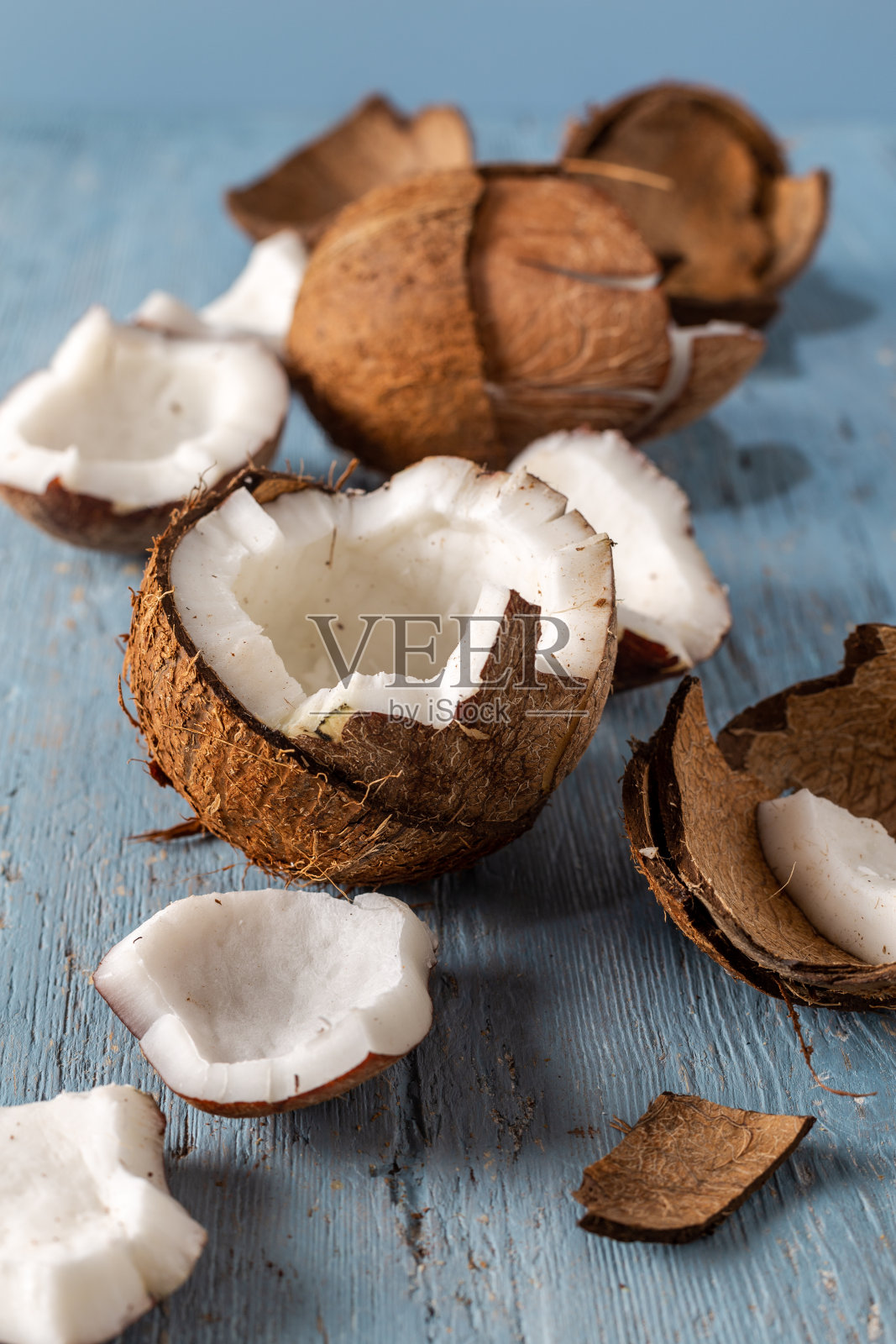 椰子的一半，椰子片上的蓝色自然木制背景照片摄影图片
