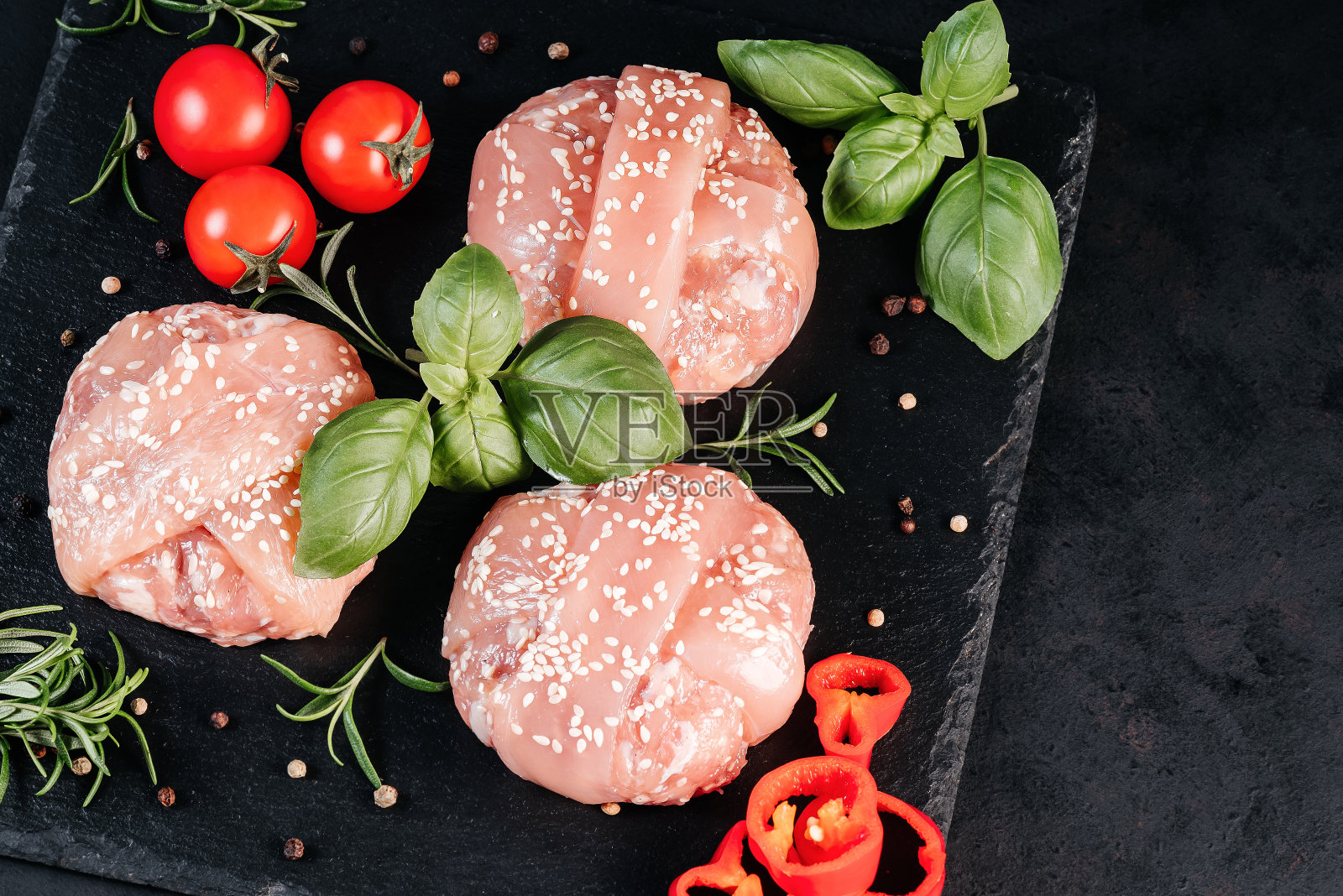 用迷迭香、西红柿、大蒜、红辣椒和其他香料做成的生鸡肉汉堡。即时的肉。烤汉堡。本空间照片摄影图片