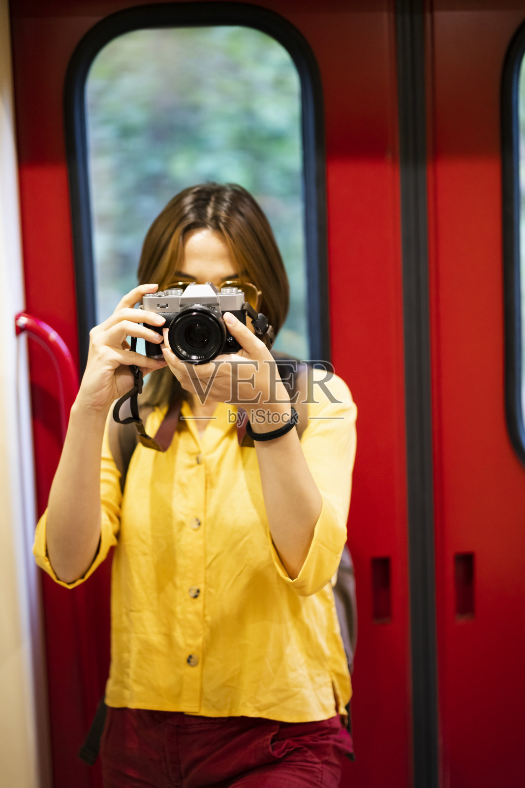 年轻女子在火车上和她的相机拍照照片摄影图片
